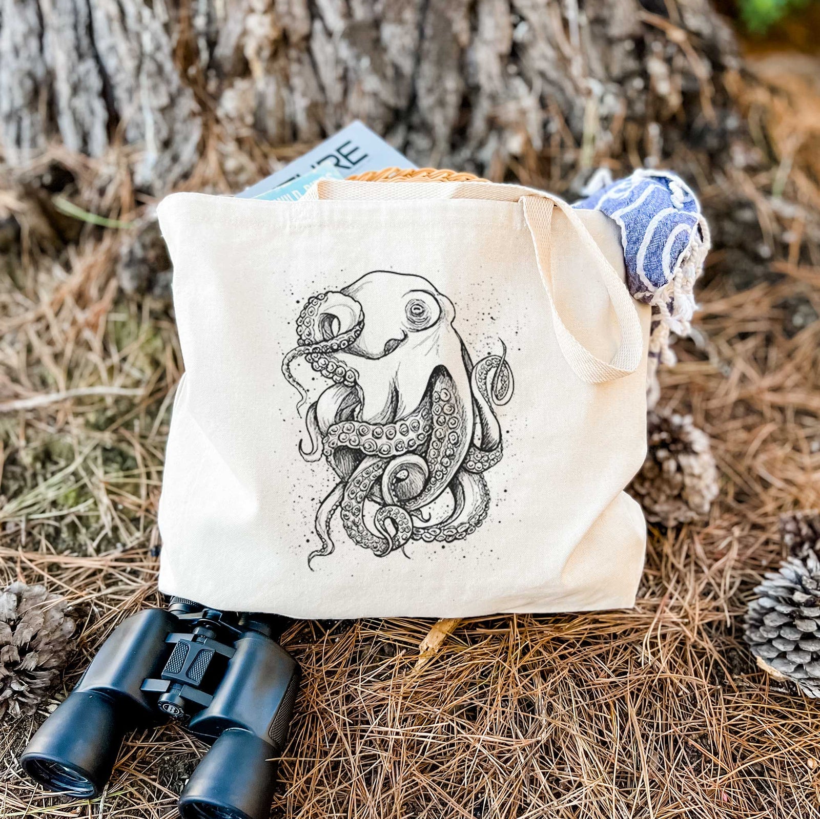 Natural canvas tote bag printed with a detailed black ink illustration of a common octopus with curling tentacles.