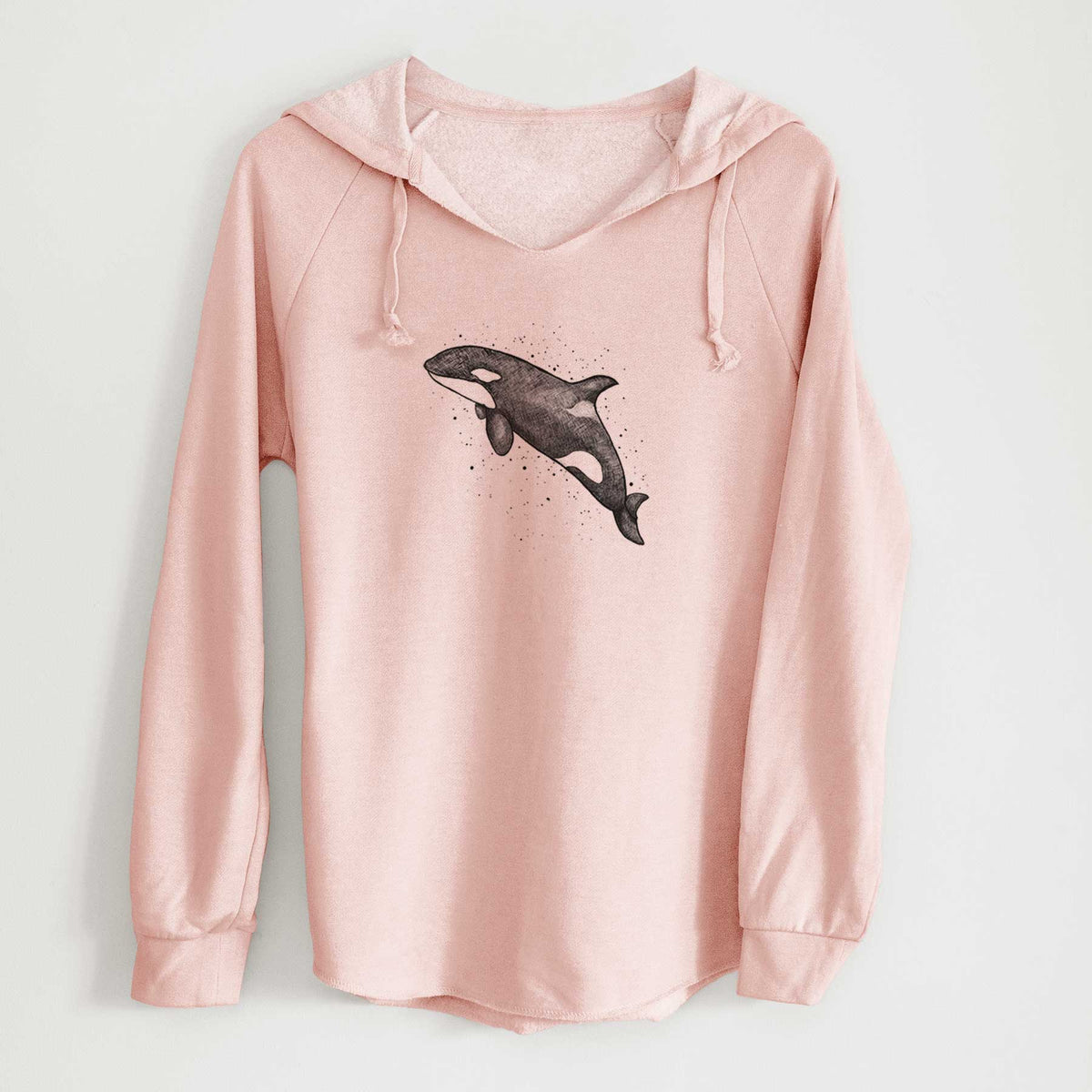 Blush pink women's Cali Wave hooded sweatshirt laid flat, printed with a black ink illustration of an orca leaping, with ink splatters.