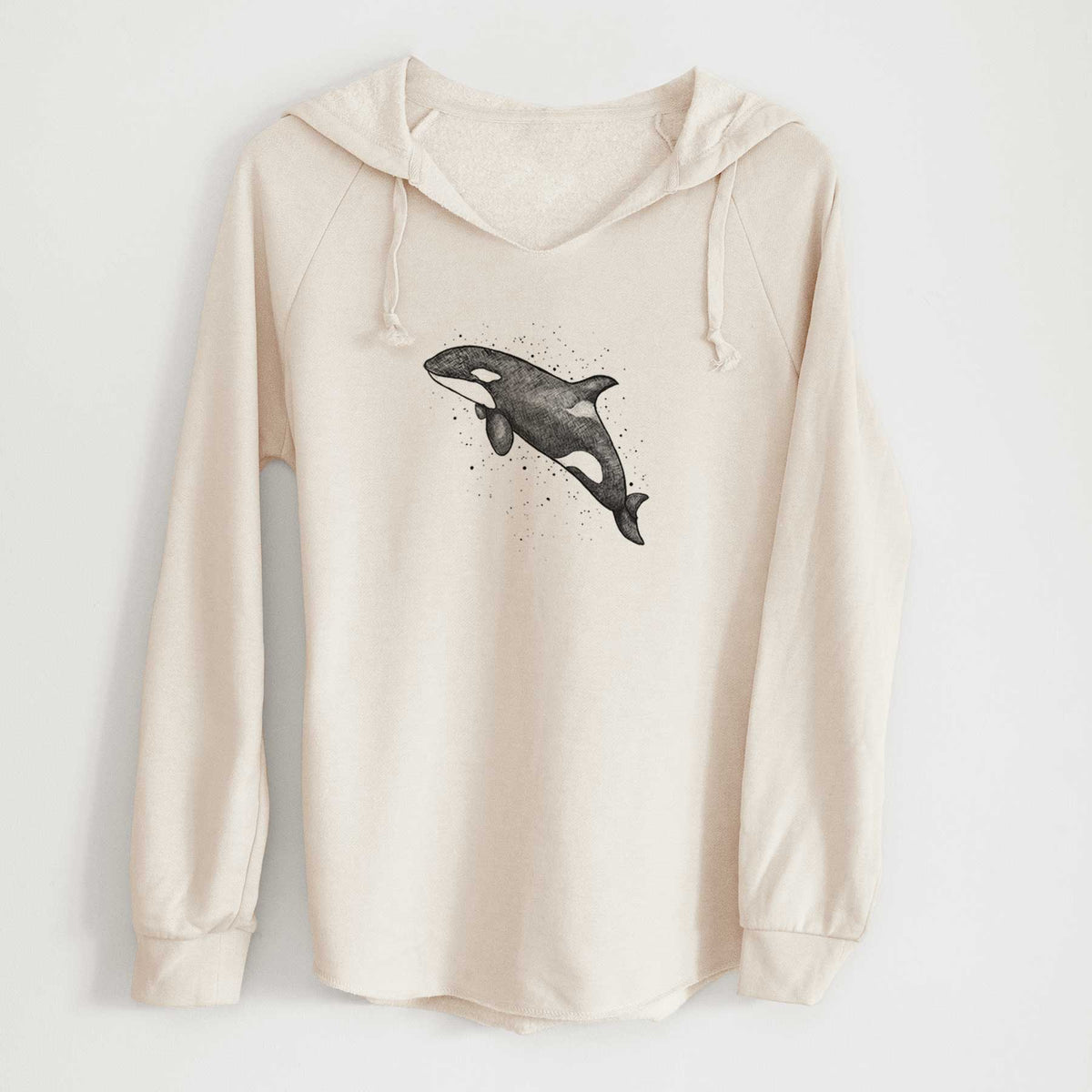 Bone cream women's Cali Wave hooded sweatshirt laid flat, printed with a black ink illustration of an orca leaping, with ink splatters.
