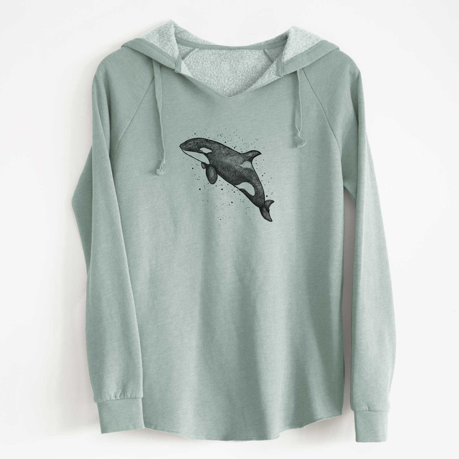 Sage green women's Cali Wave hooded sweatshirt laid flat, printed with a black ink illustration of an orca leaping, with ink splatters.