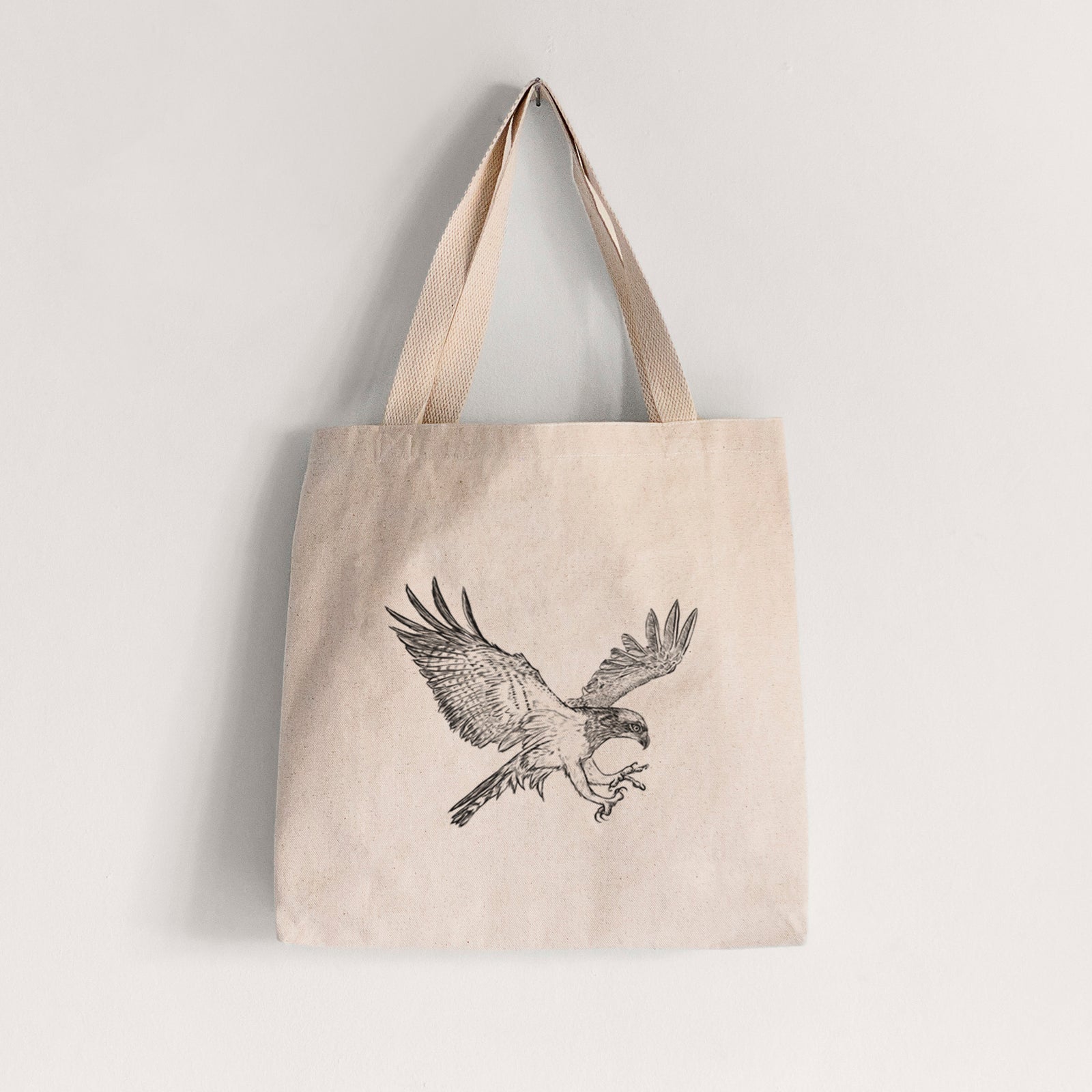 Natural canvas tote bag printed with a black ink illustration of an osprey in flight with its wings spread.