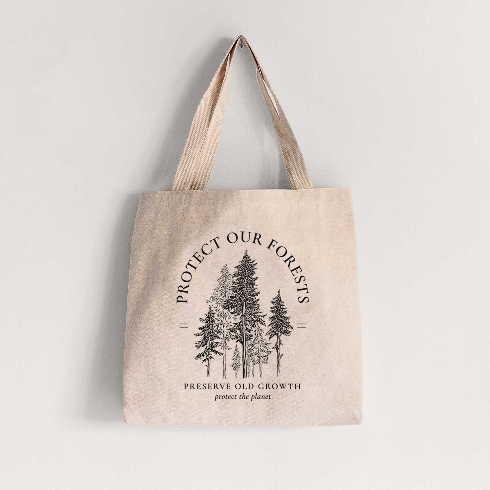 Natural canvas tote bag printed with a black ink illustration of a stand of tall pine trees, framed by the words Protect Our Forests, Preserve Old Growth.