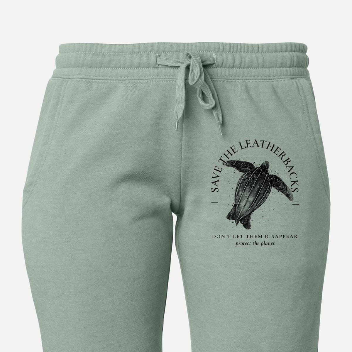 Front of sage green Cali Wave sweatpants, printed with a black ink leatherback sea turtle framed by the words Save the Leatherbacks, Don't Let Them Disappear on the leg.