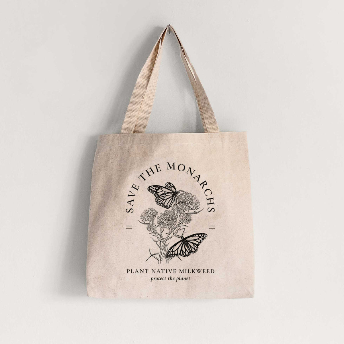 Natural canvas tote bag printed with black ink monarch butterflies on milkweed flowers, framed by the words Save the Monarchs, Plant Native Milkweed.