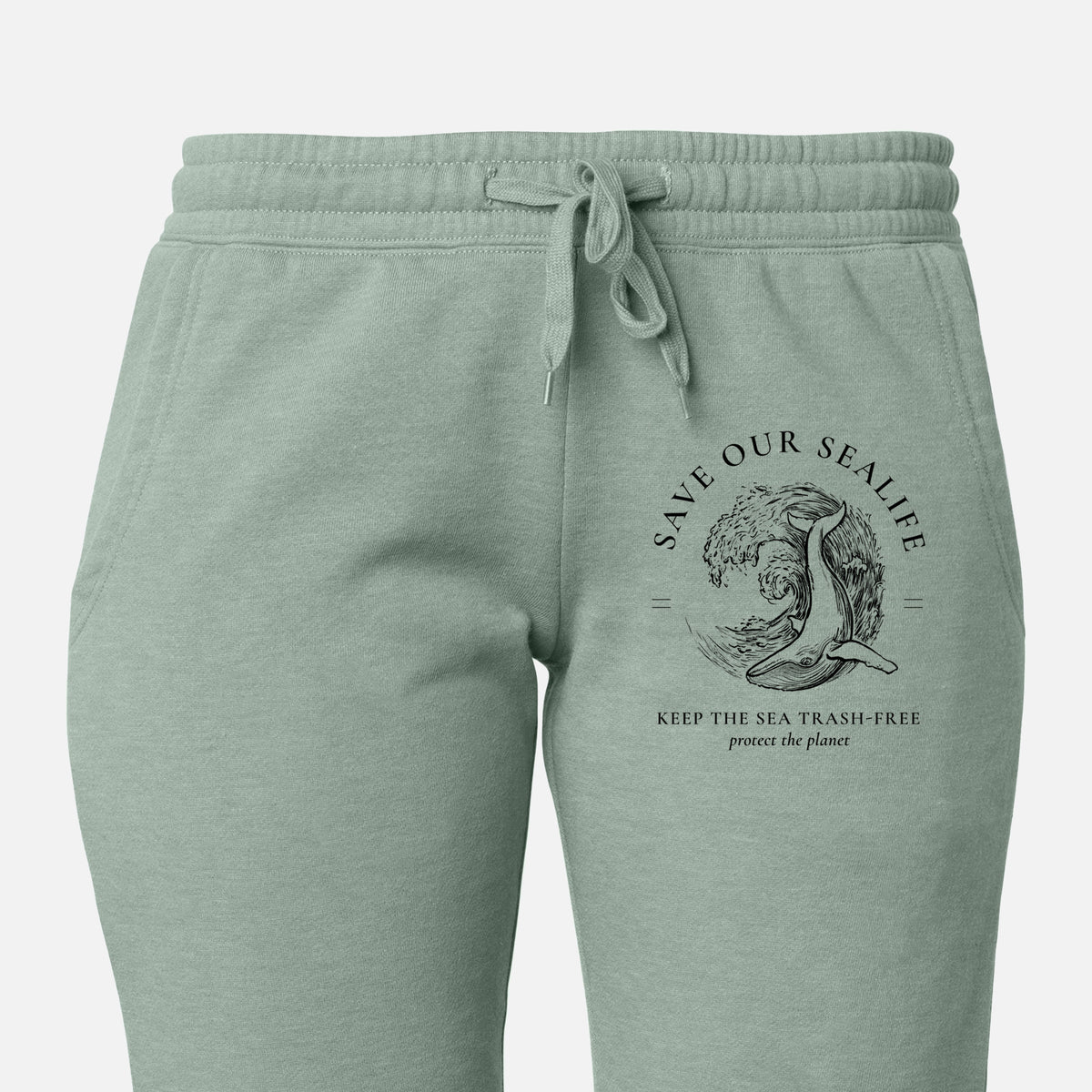 Front of sage green Cali Wave sweatpants, printed with a black ink whale in an ocean wave framed by the words Save Our Sealife, Keep the Sea Trash-Free on the leg.