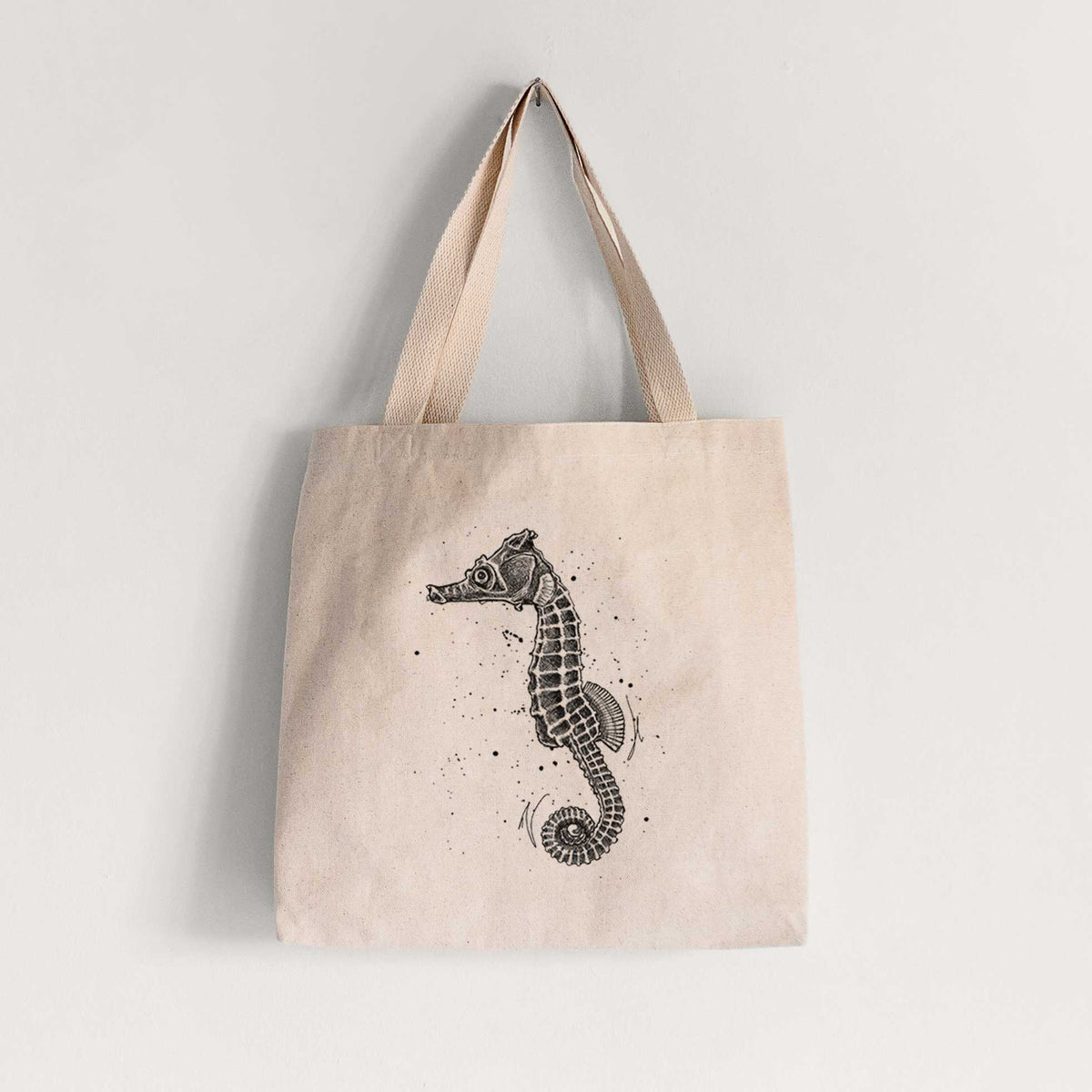 Natural canvas tote bag printed with a detailed black ink illustration of a Pacific seahorse with its tail curled.