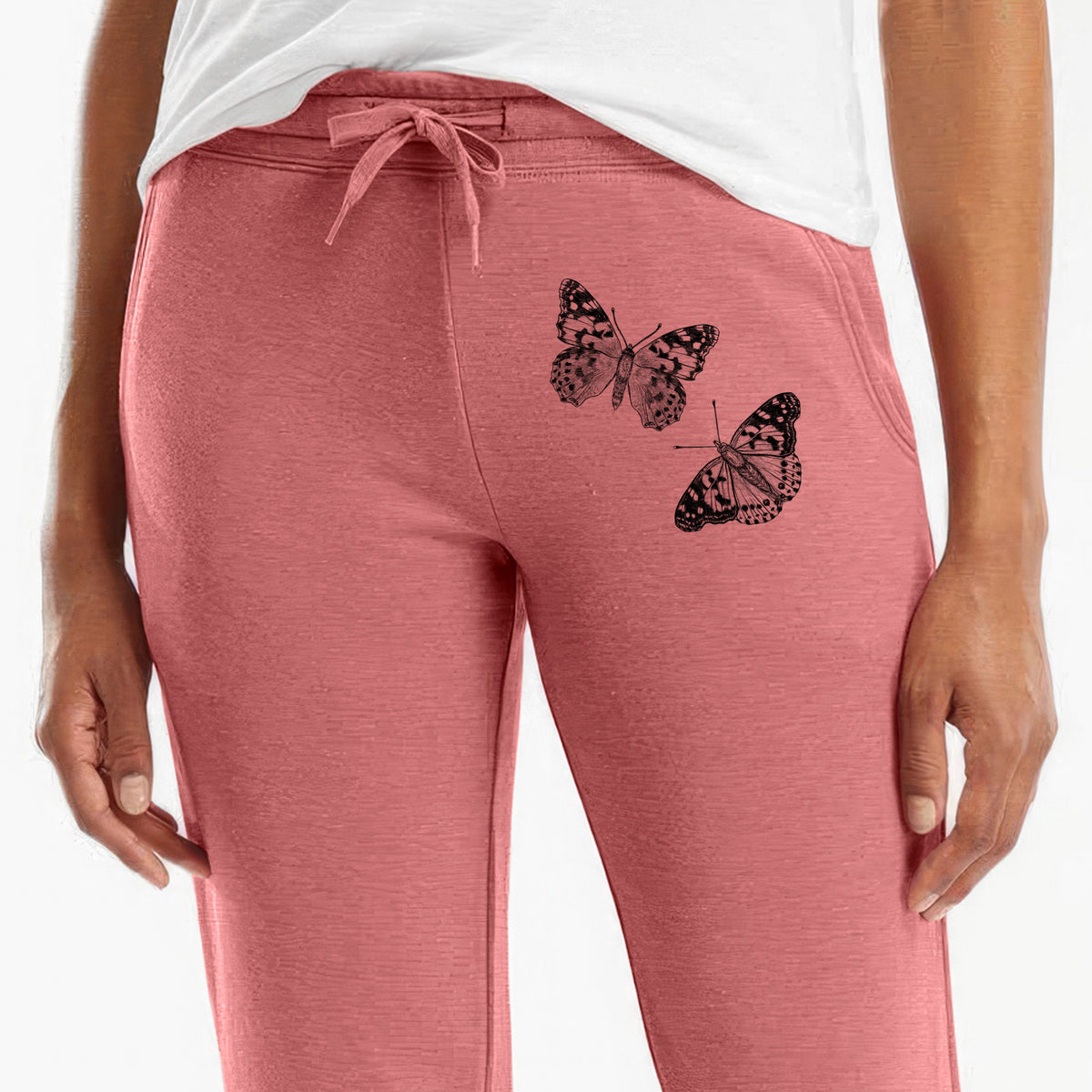 Front of dusty rose Cali Wave sweatpants, printed with a detailed black ink illustration of two painted lady butterflies on the leg.