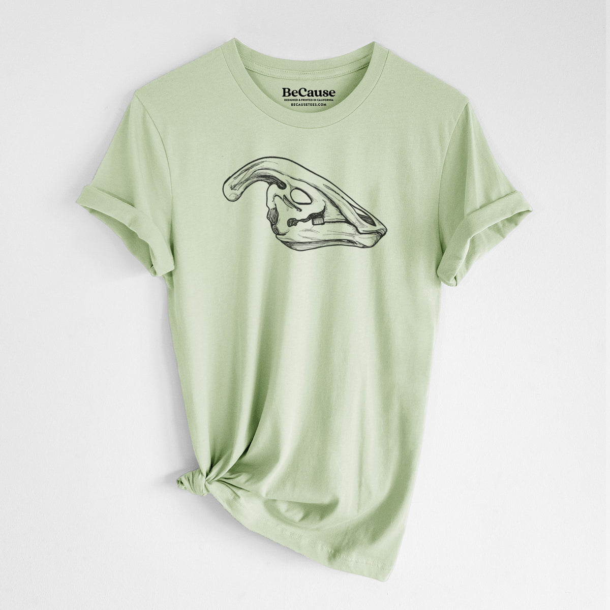 Spring green lightweight cotton t-shirt laid flat with the sleeves rolled, printed with a detailed black ink illustration of a crested Parasaurolophus skull.