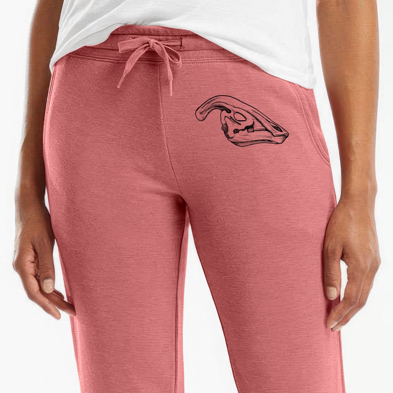 Front of dusty rose Cali Wave sweatpants, printed with a detailed black ink illustration of a crested Parasaurolophus skull on the leg.