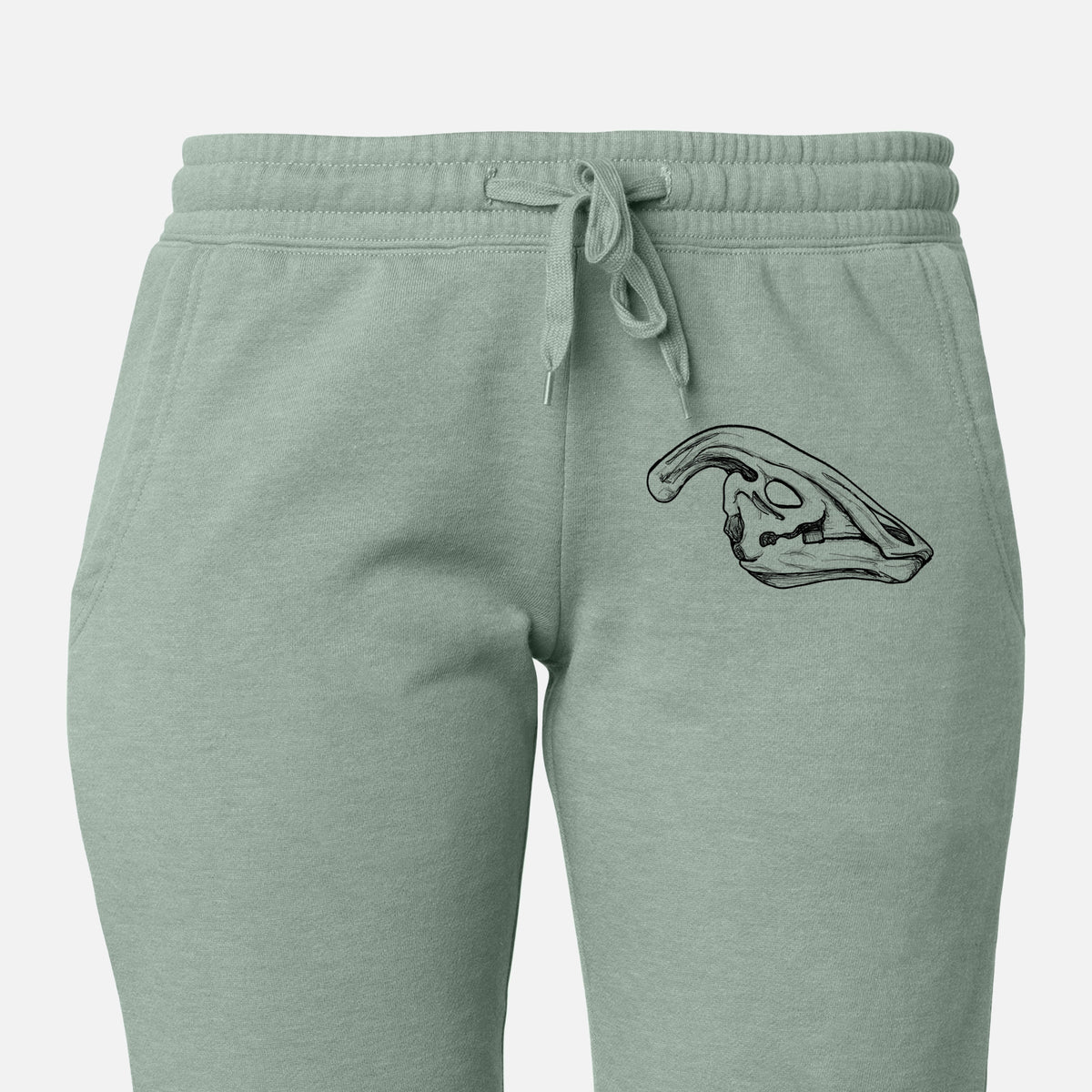 Front of sage green Cali Wave sweatpants, printed with a detailed black ink illustration of a crested Parasaurolophus skull on the leg.