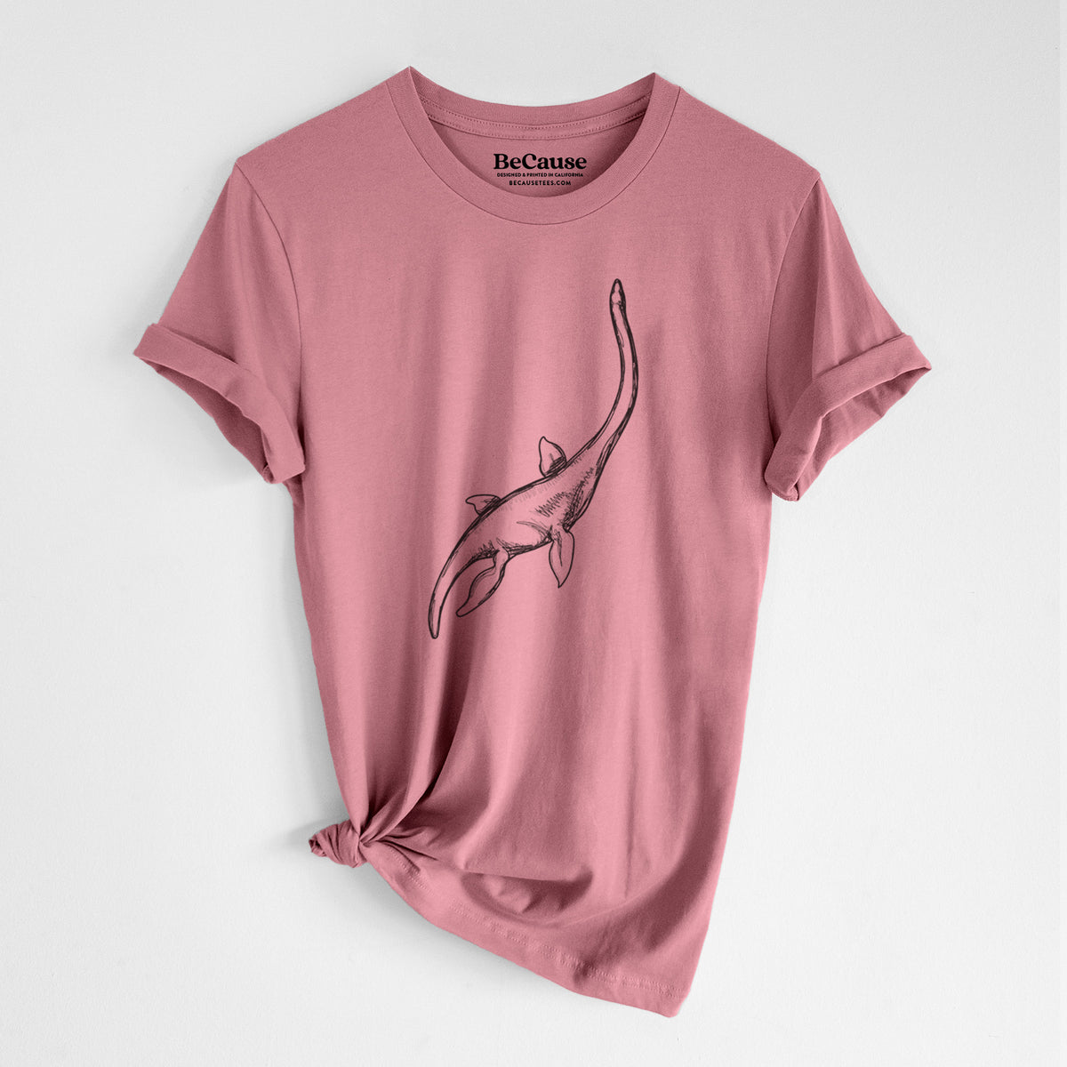 Mauve pink lightweight cotton t-shirt laid flat with the sleeves rolled, printed with a black ink illustration of a long-necked plesiosaur swimming.