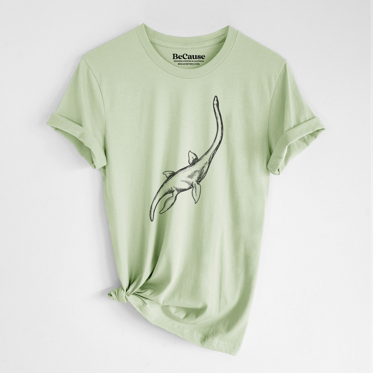 Spring green lightweight cotton t-shirt laid flat with the sleeves rolled, printed with a black ink illustration of a long-necked plesiosaur swimming.
