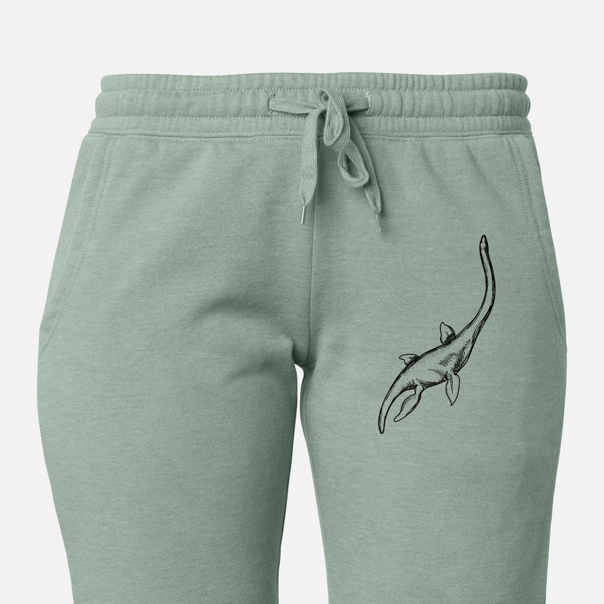 Front of sage green Cali Wave sweatpants, printed with a black ink illustration of a long-necked plesiosaur swimming on the leg.
