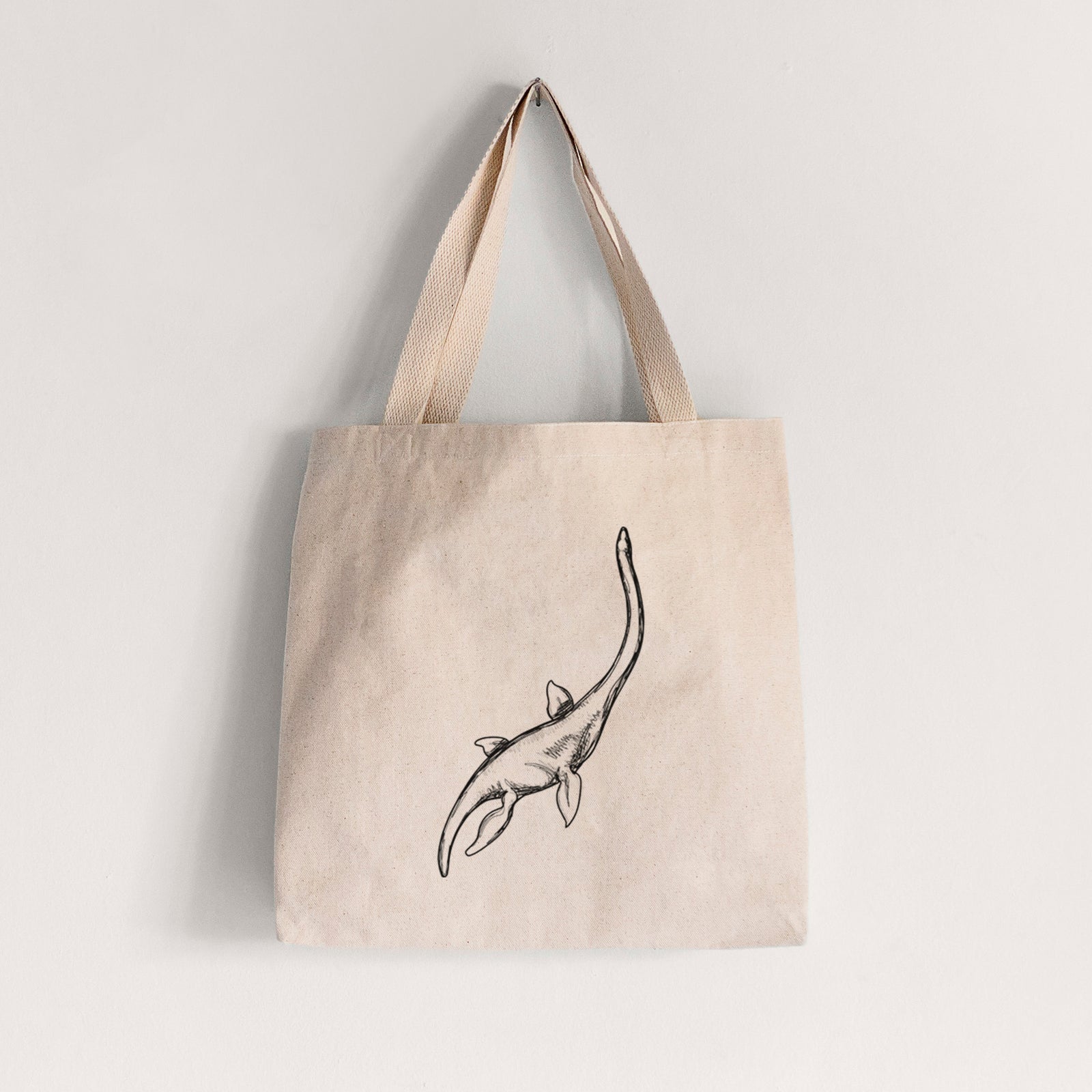 Natural canvas tote bag printed with a black ink illustration of a long-necked plesiosaur swimming.