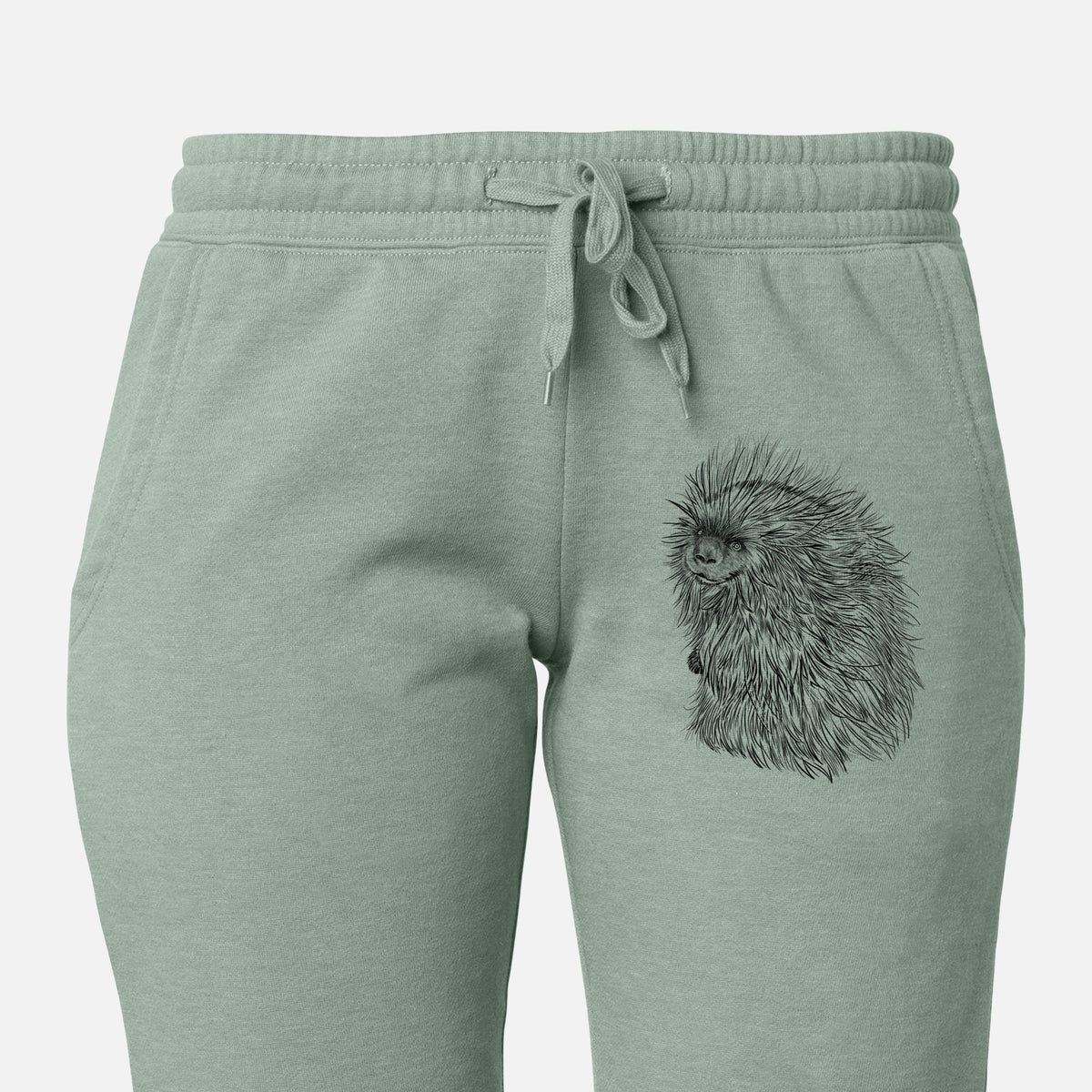 Front of sage green Cali Wave sweatpants, printed with a detailed black ink illustration of a porcupine with its quills raised on the leg.