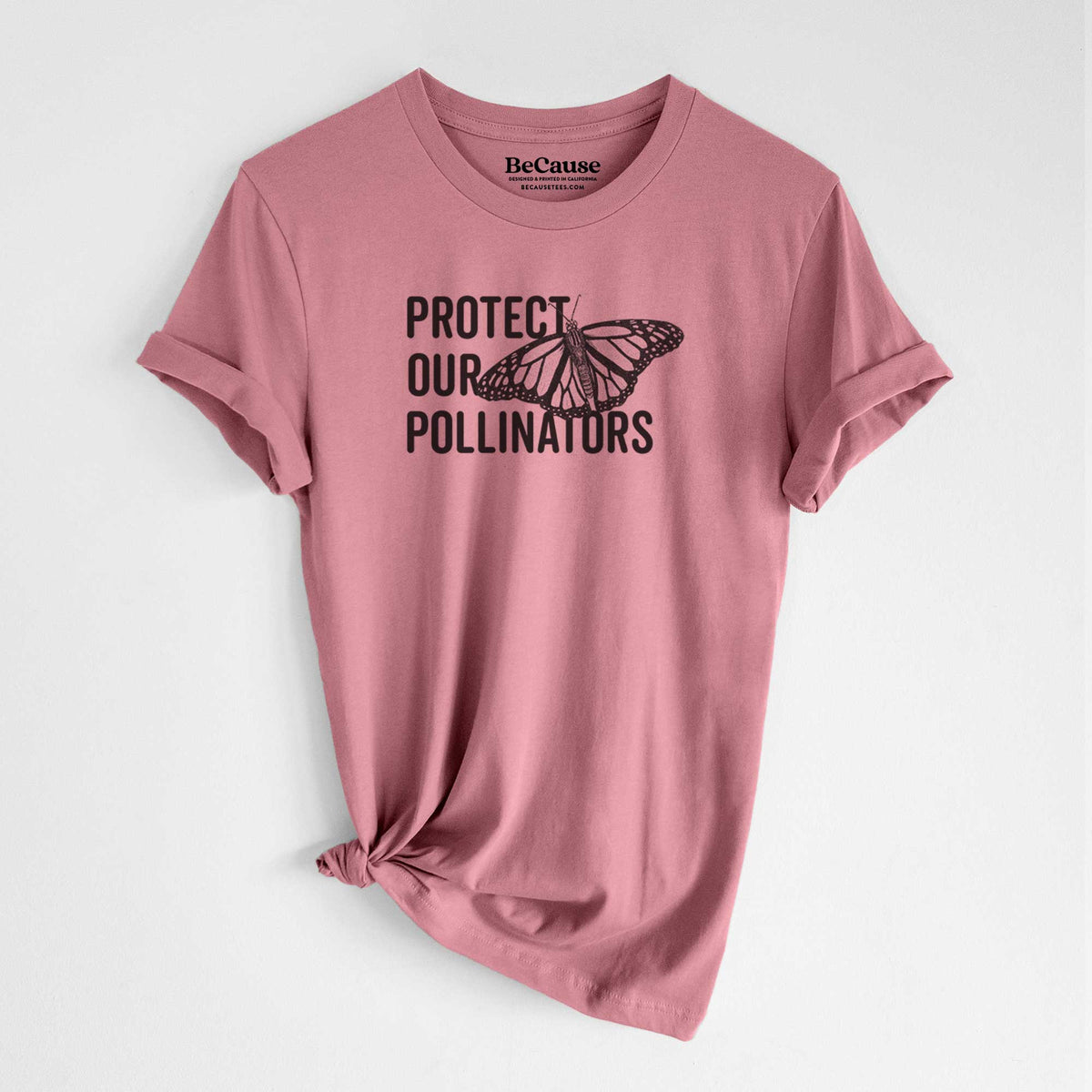 Mauve pink lightweight cotton t-shirt laid flat with the sleeves rolled, printed with bold black words reading Protect Our Pollinators beside a monarch butterfly.