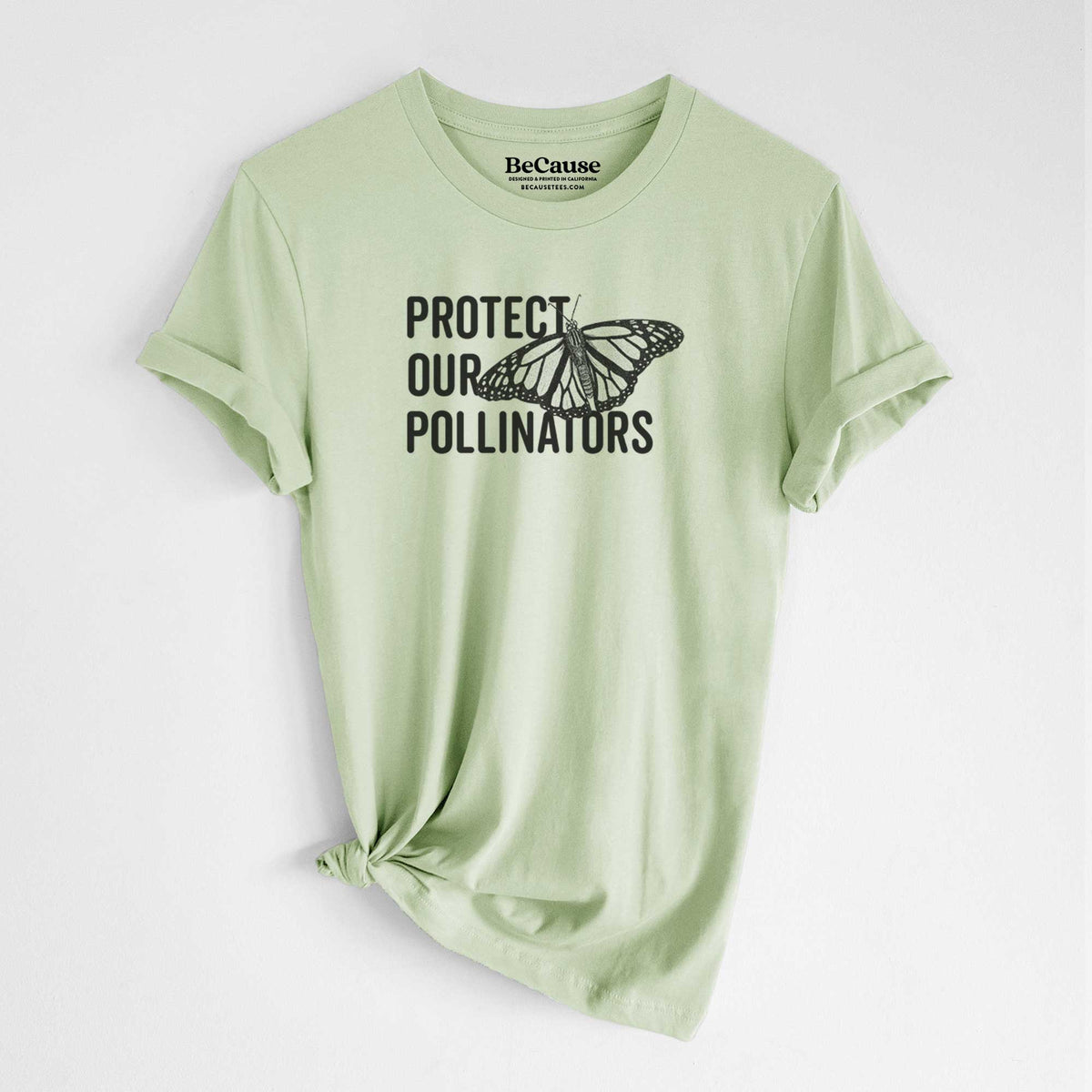 Spring green lightweight cotton t-shirt laid flat with the sleeves rolled, printed with bold black words reading Protect Our Pollinators beside a monarch butterfly.