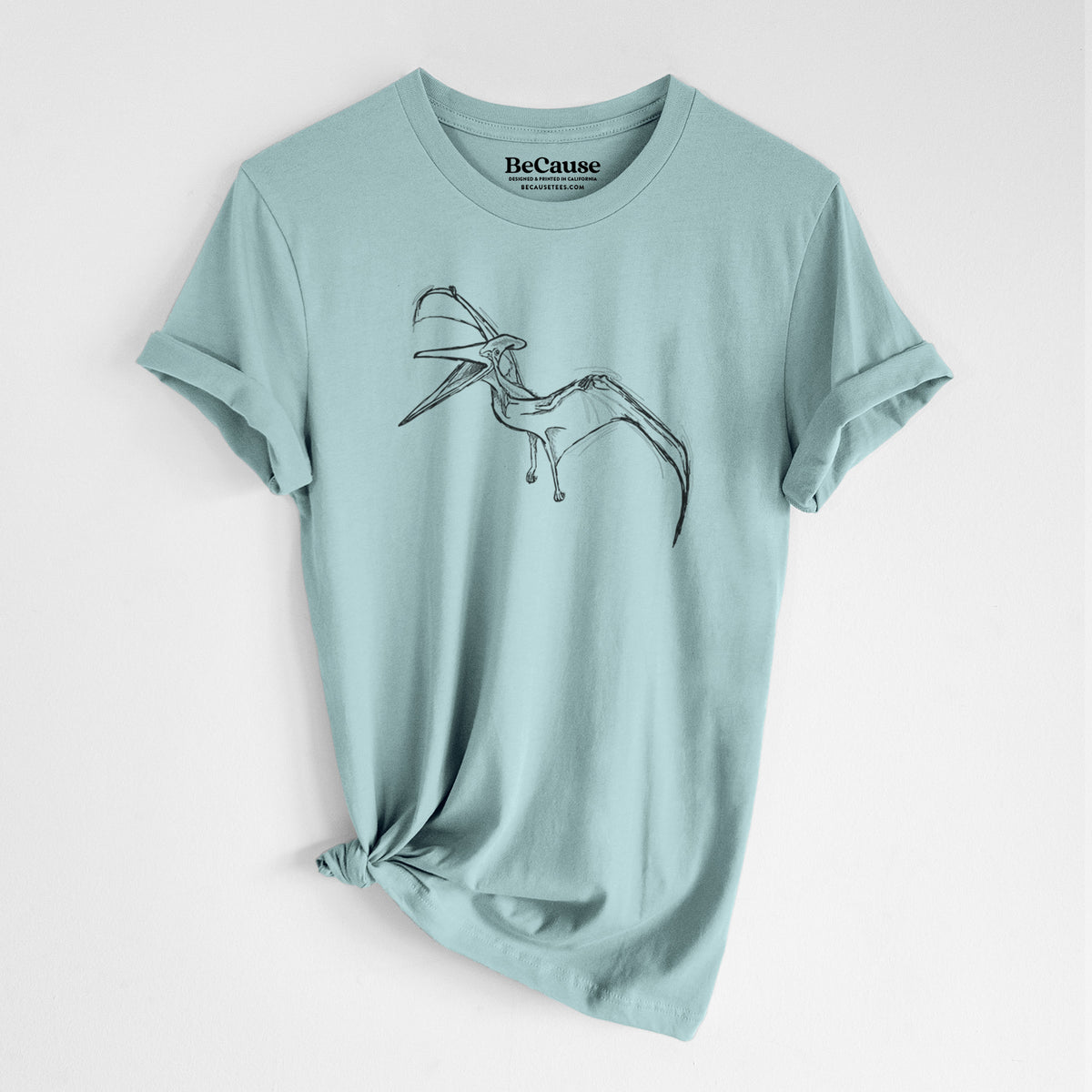 Dusty blue lightweight cotton t-shirt laid flat with the sleeves rolled, printed with a black ink illustration of a Pteranodon in flight.