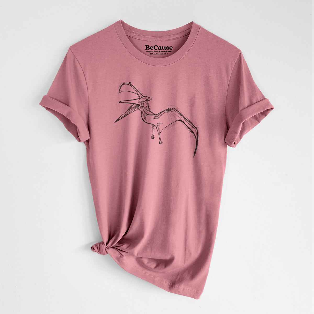 Mauve pink lightweight cotton t-shirt laid flat with the sleeves rolled, printed with a black ink illustration of a Pteranodon in flight.