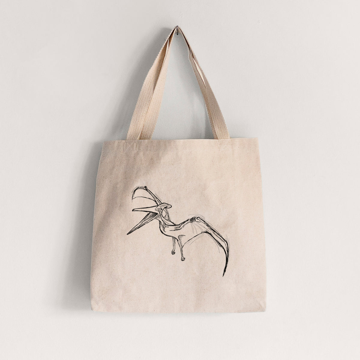 Natural canvas tote bag printed with a black ink illustration of a Pteranodon in flight.