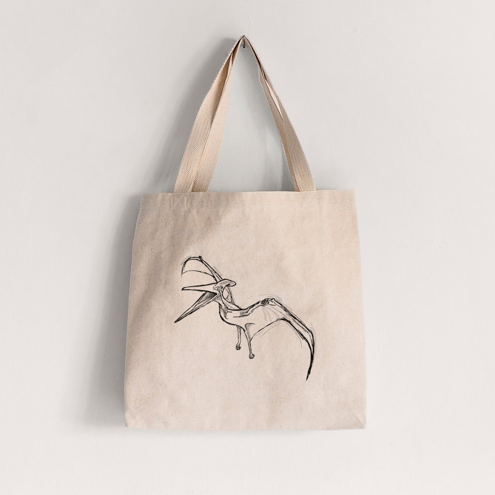 Natural canvas tote bag printed with a black ink illustration of a Pteranodon in flight.