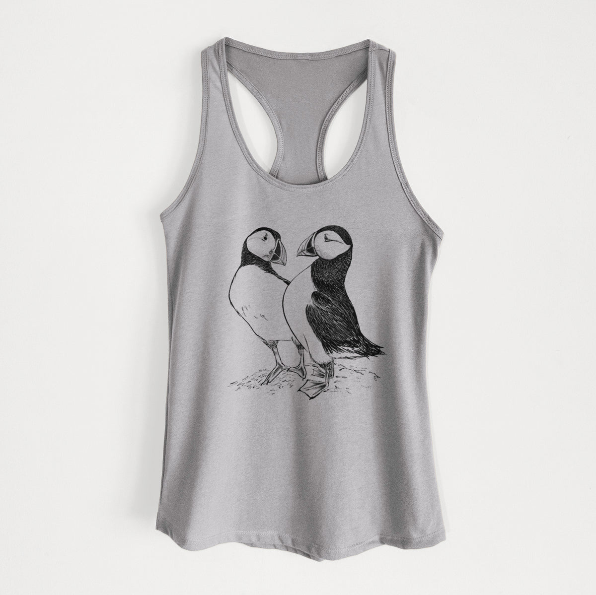 Heather grey women's racerback tank top laid flat, printed with a detailed black ink illustration of two Atlantic puffins standing side by side.