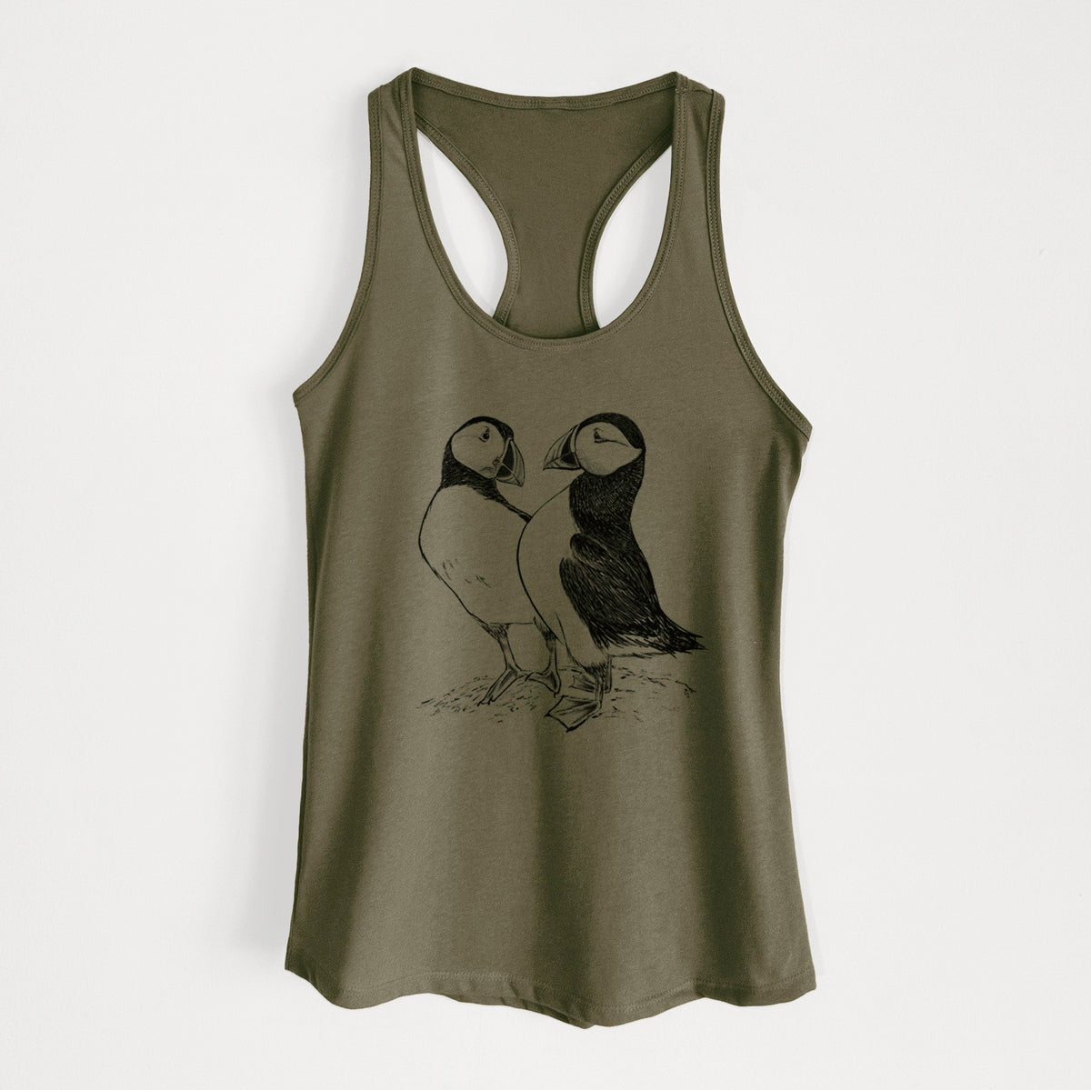 Military green women's racerback tank top laid flat, printed with a detailed black ink illustration of two Atlantic puffins standing side by side.