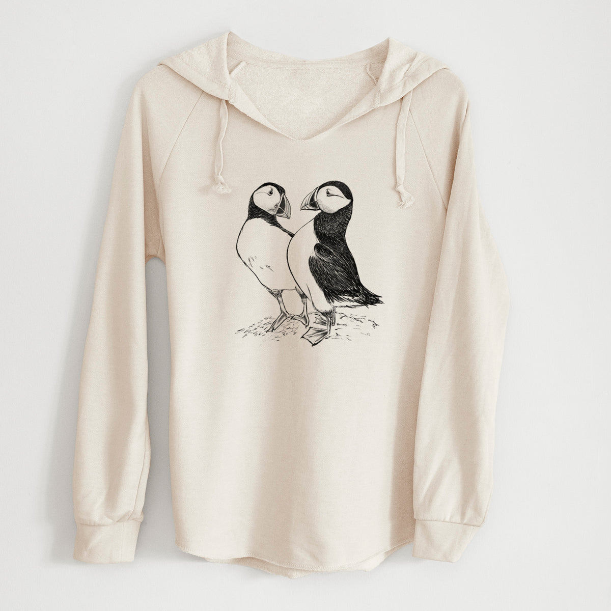 Bone cream women's Cali Wave hooded sweatshirt laid flat, printed with a detailed black ink illustration of two Atlantic puffins standing side by side.
