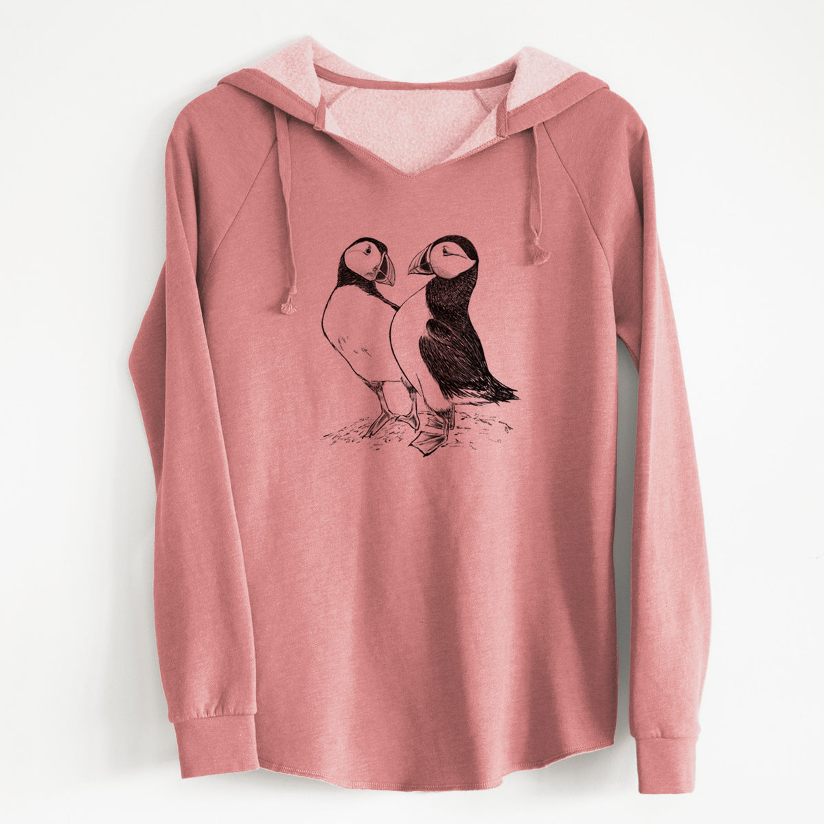 Dusty rose women's Cali Wave hooded sweatshirt laid flat, printed with a detailed black ink illustration of two Atlantic puffins standing side by side.
