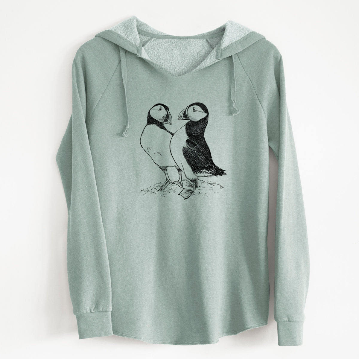 Sage green women's Cali Wave hooded sweatshirt laid flat, printed with a detailed black ink illustration of two Atlantic puffins standing side by side.