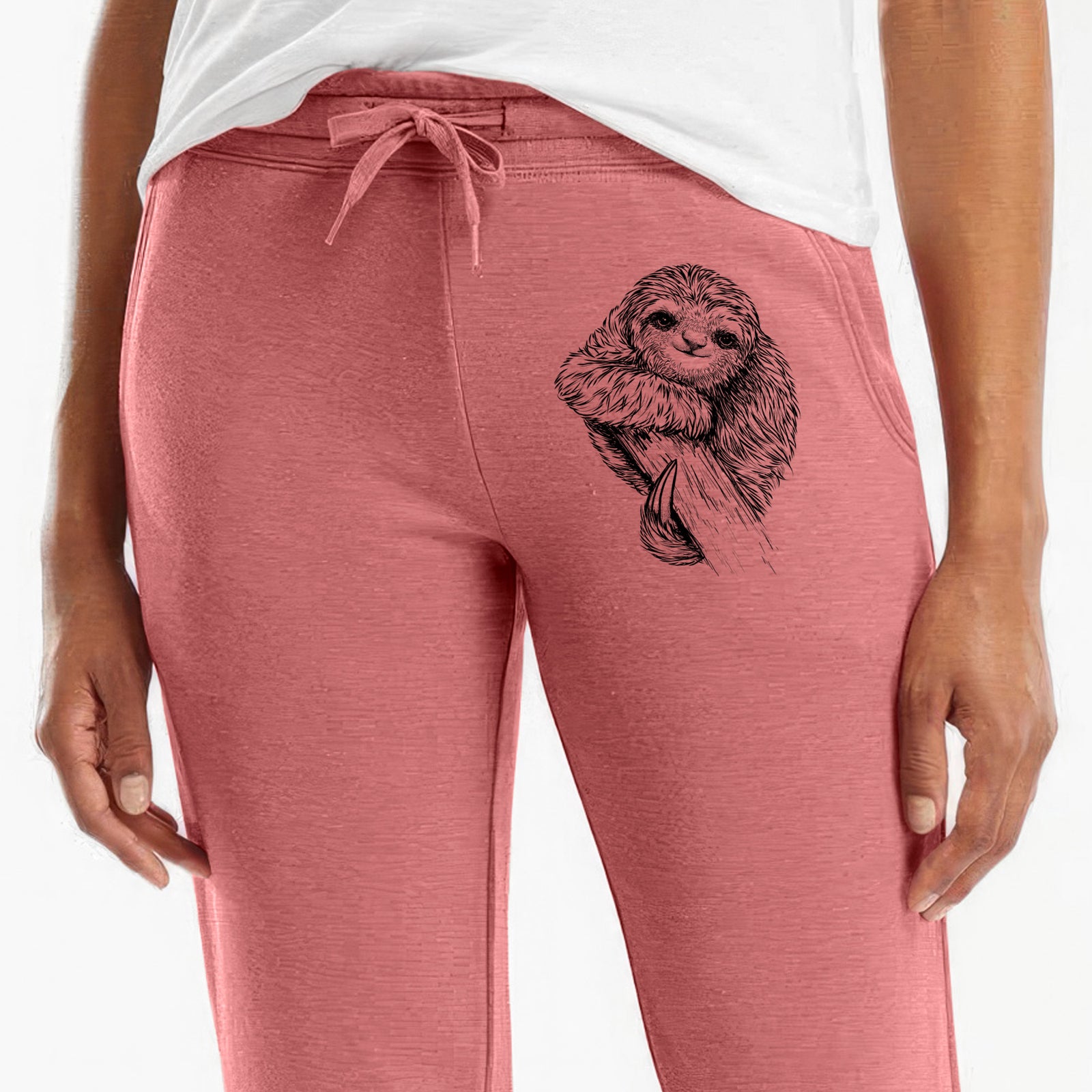 Front of dusty rose Cali Wave sweatpants, printed with a detailed black ink illustration of a smiling pygmy three-toed sloth hanging from a branch on the leg.