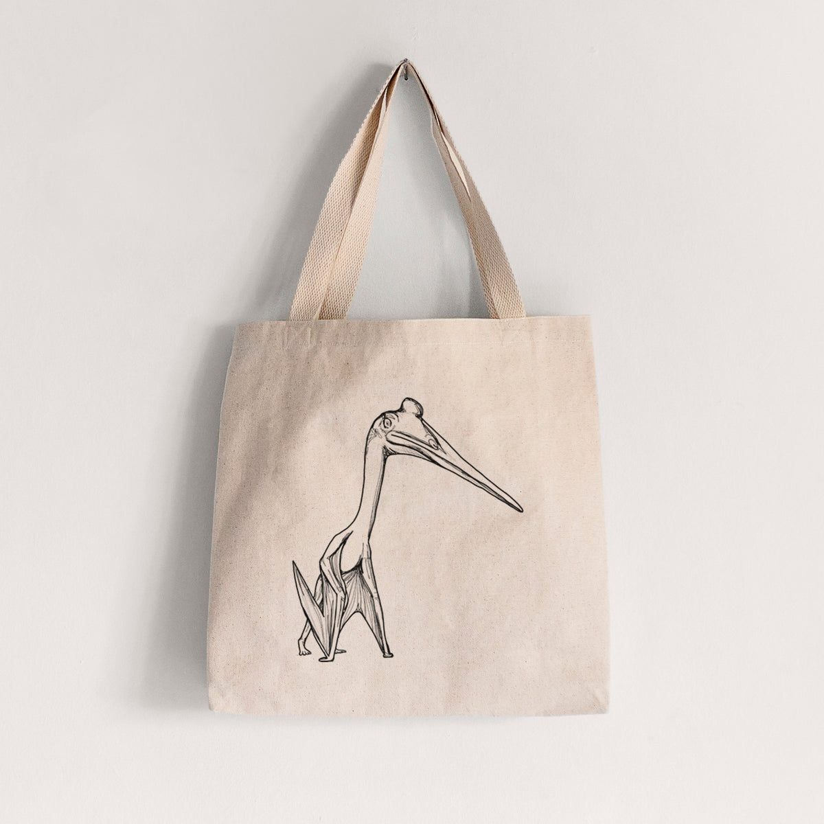 Natural canvas tote bag printed with a black ink illustration of a Quetzalcoatlus pterosaur standing on all fours.