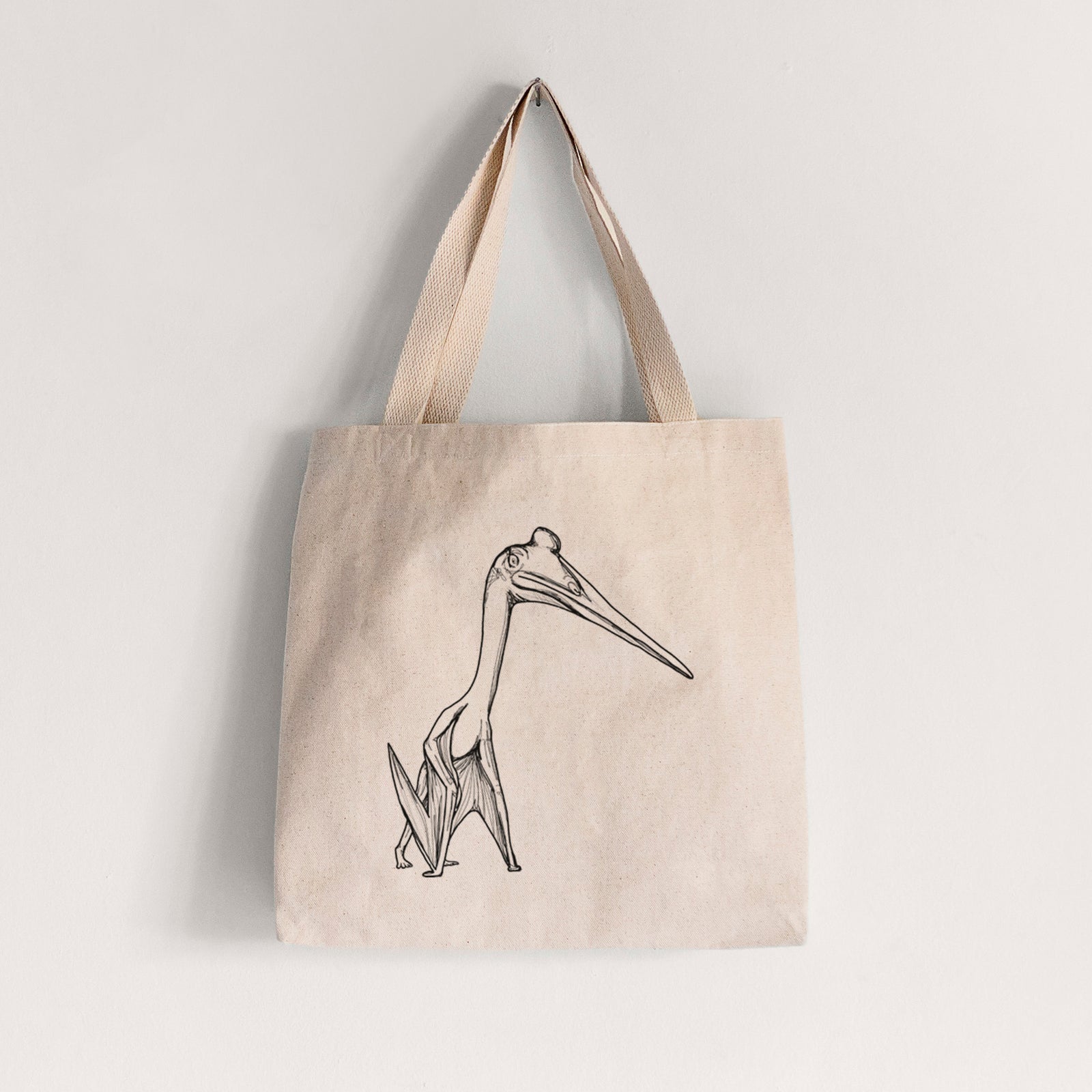 Natural canvas tote bag printed with a black ink illustration of a Quetzalcoatlus pterosaur standing on all fours.