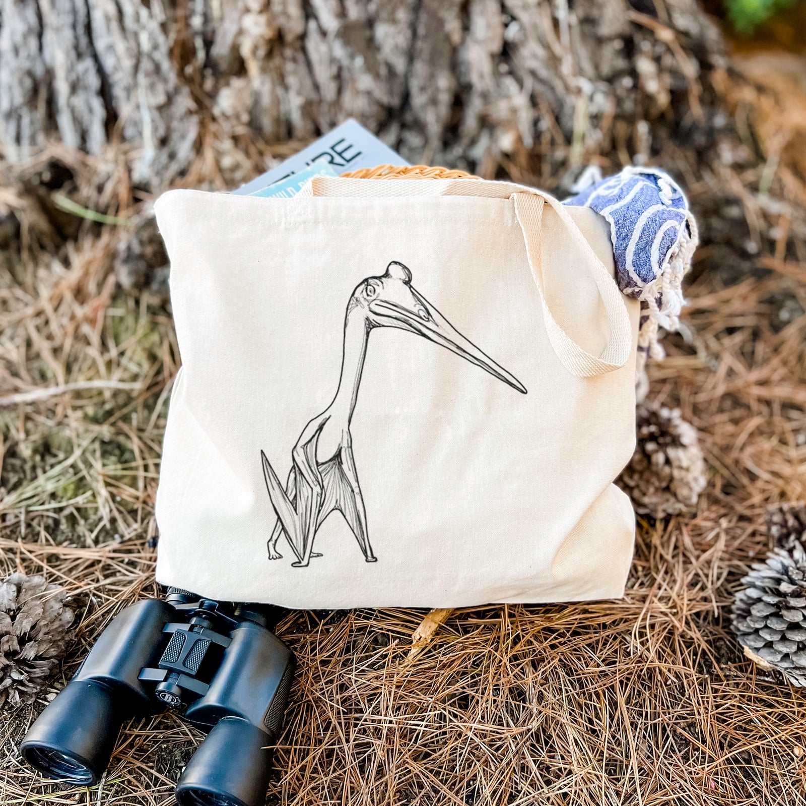 Natural canvas tote bag printed with a black ink illustration of a Quetzalcoatlus pterosaur standing on all fours.