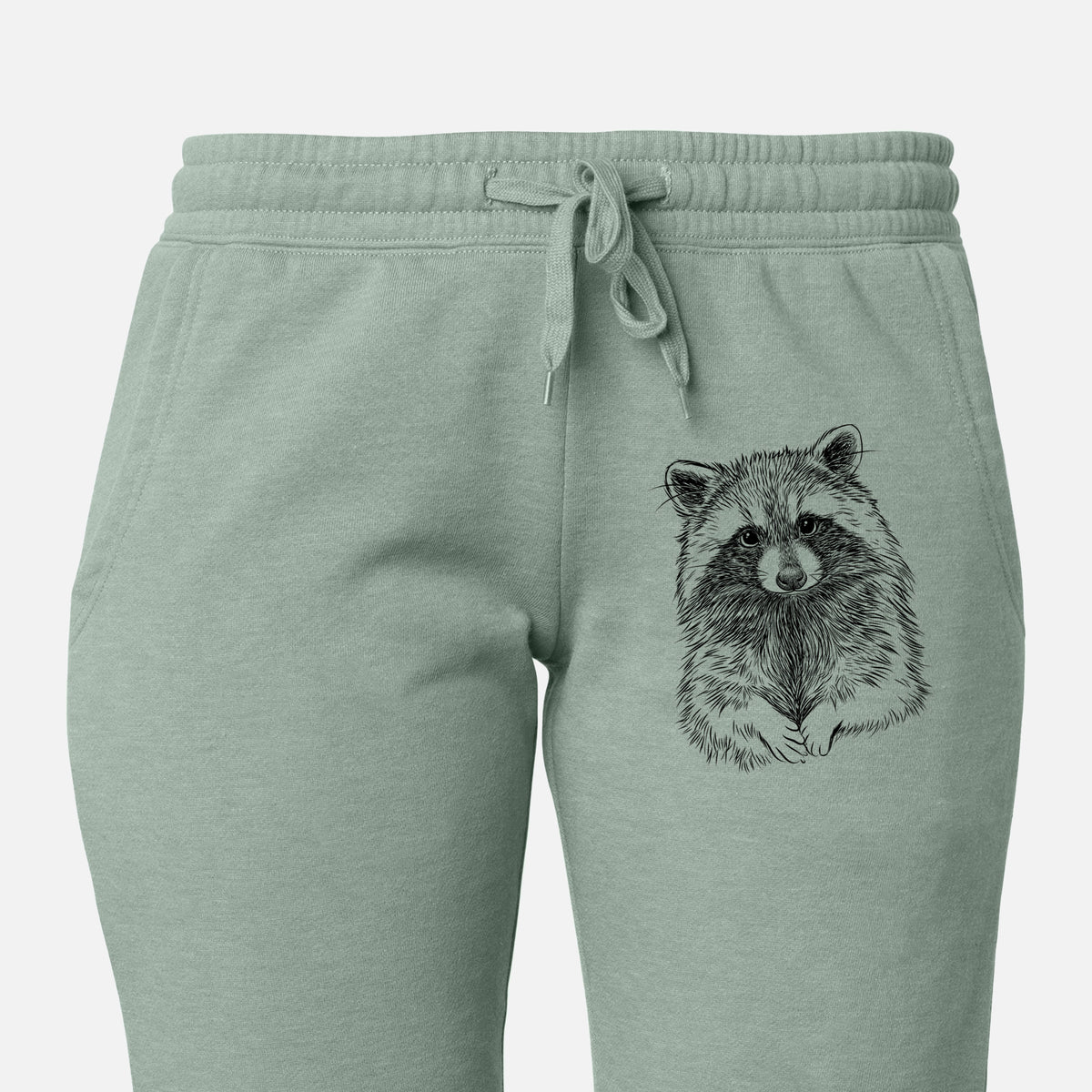 Front of sage green Cali Wave sweatpants, printed with a detailed black ink portrait of a raccoon with its front paws resting in front of it on the leg.
