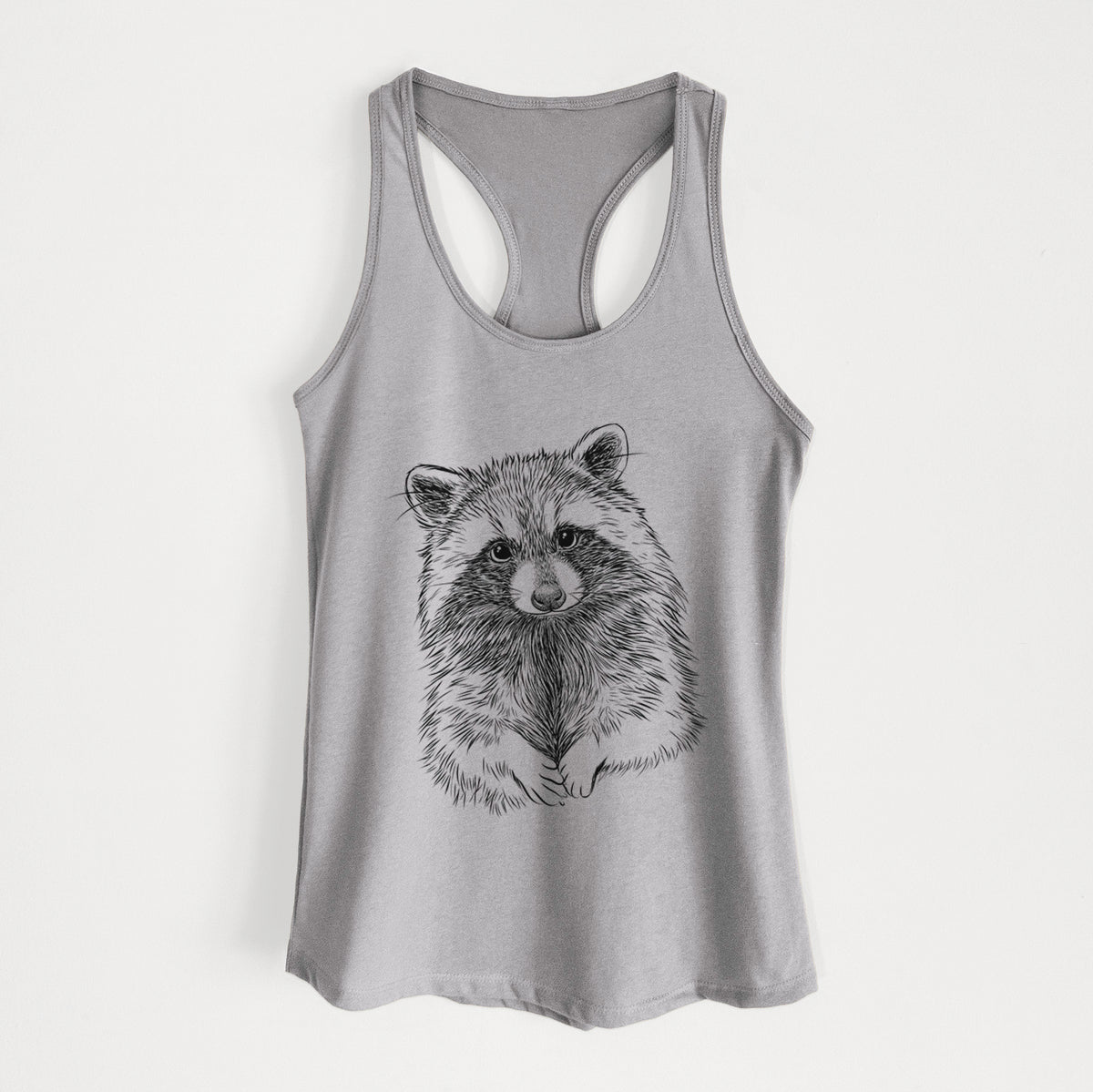 Heather grey women's racerback tank top laid flat, printed with a detailed black ink portrait of a raccoon with its front paws resting in front of it.