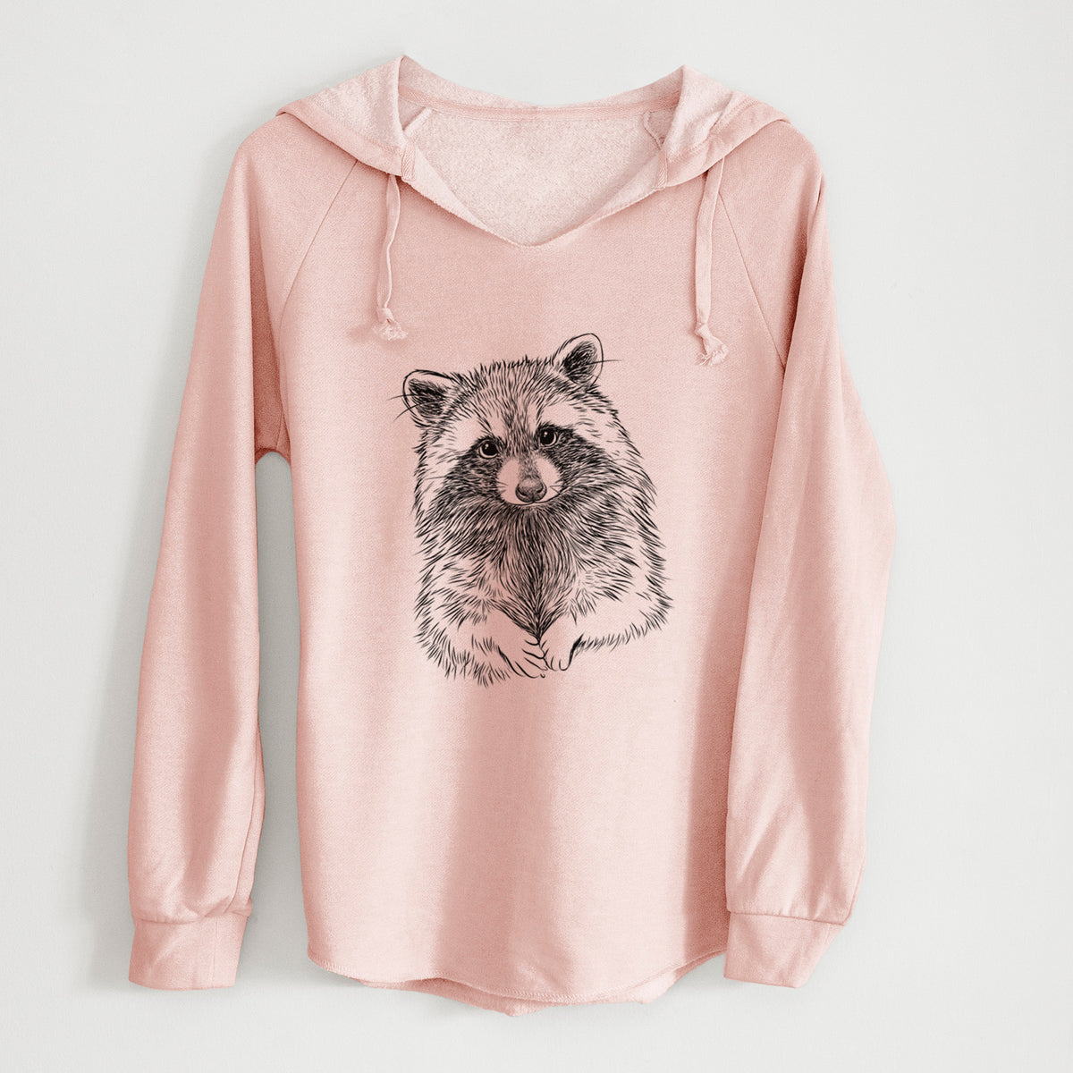 Blush pink women's Cali Wave hooded sweatshirt laid flat, printed with a detailed black ink portrait of a raccoon with its front paws resting in front of it.