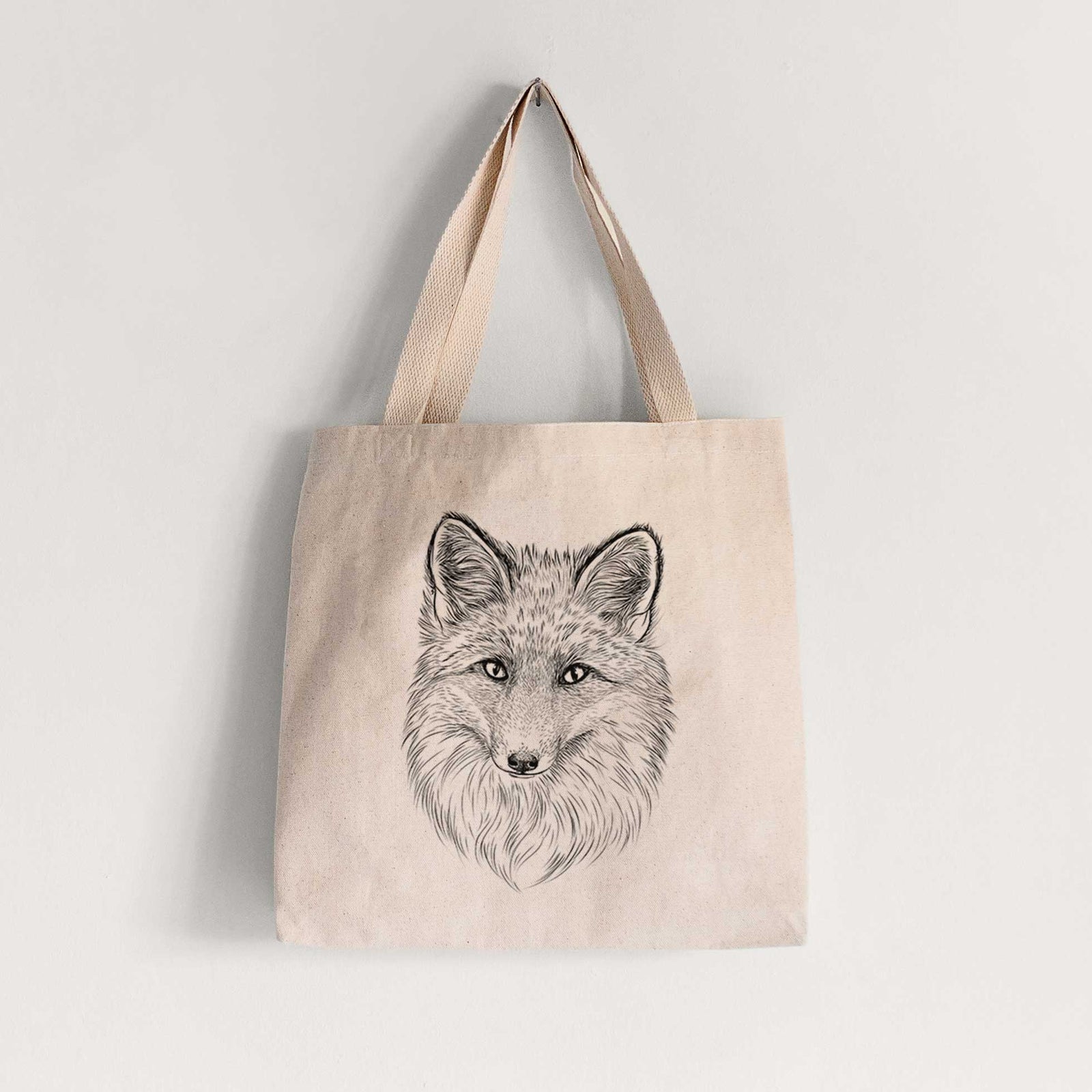 Natural canvas tote bag printed with a detailed black ink sketch of a red fox's face looking straight ahead, its fur drawn in fine pencil-like strokes.