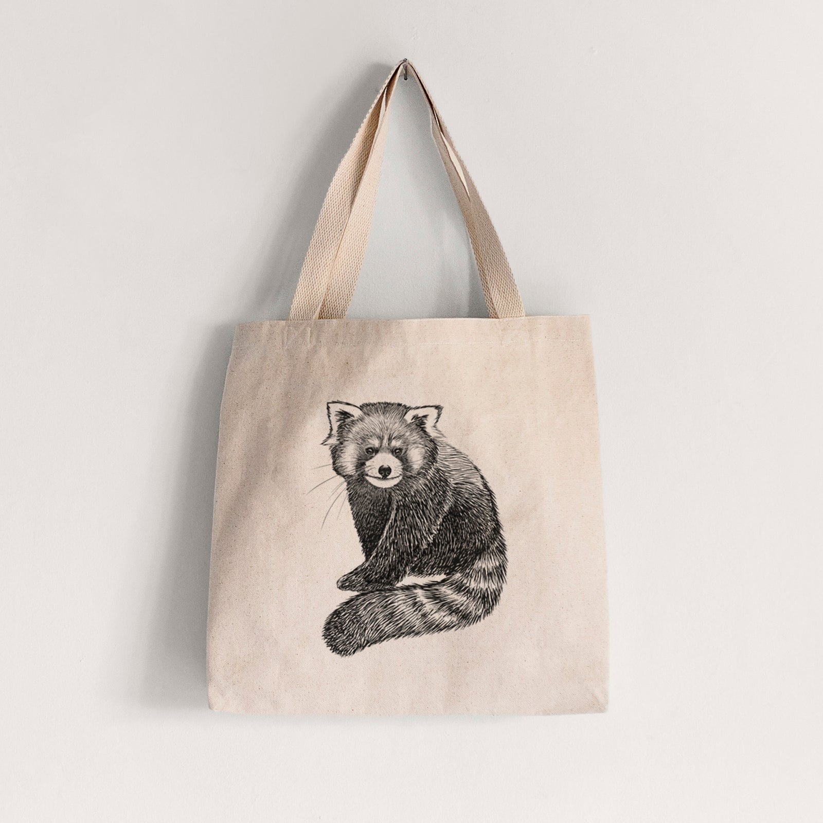 Natural canvas tote bag printed with a detailed black ink illustration of a red panda sitting with its striped tail wrapped around.