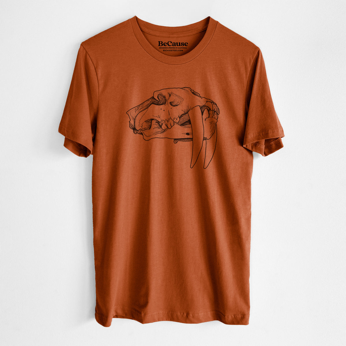 Autumn lightweight cotton t-shirt laid flat, printed with a detailed black ink illustration of a saber-toothed tiger skull.