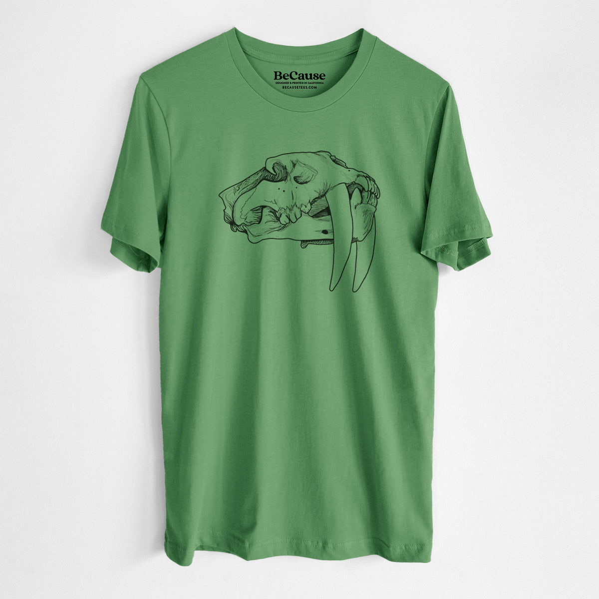 Leaf green lightweight cotton t-shirt laid flat, printed with a detailed black ink illustration of a saber-toothed tiger skull.