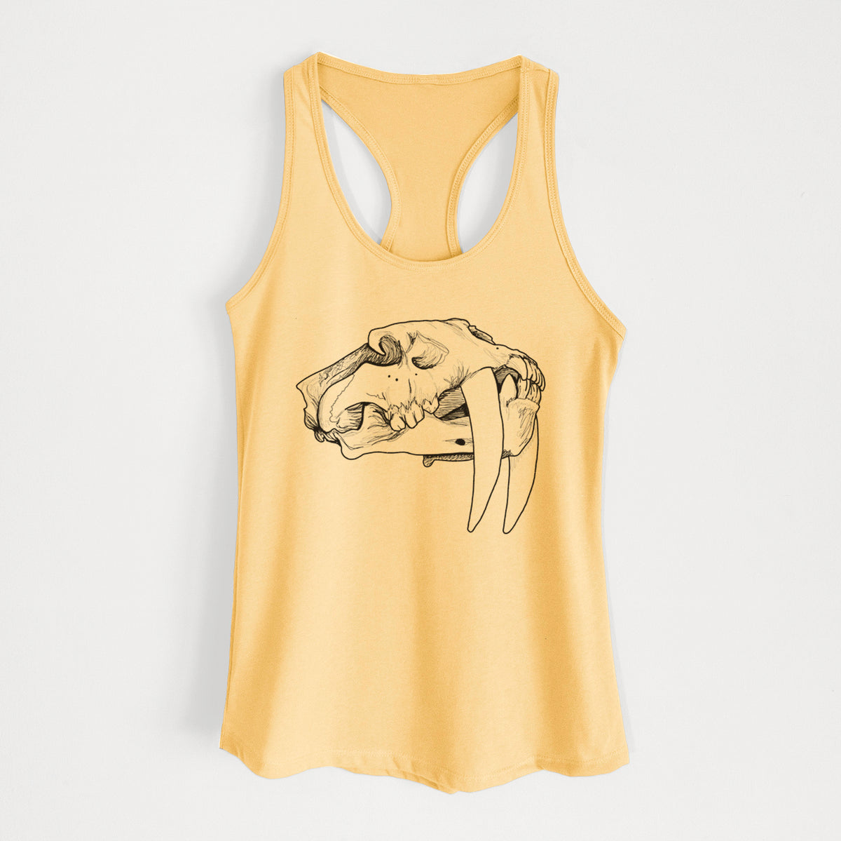 Banana cream women's racerback tank top laid flat, printed with a detailed black ink illustration of a saber-toothed tiger skull.