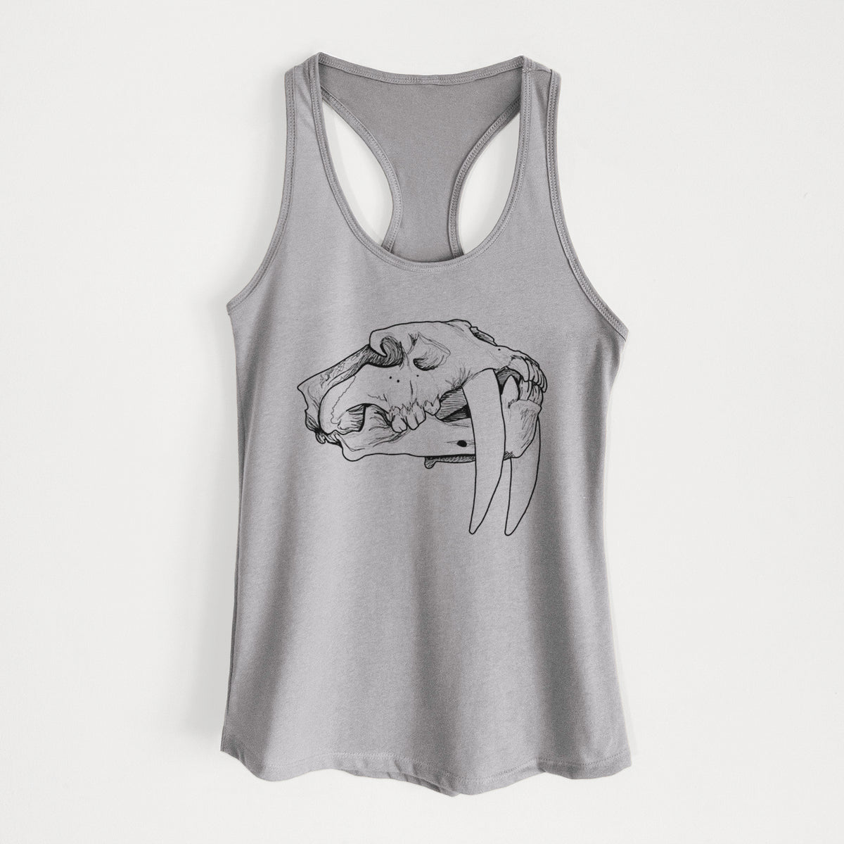 Heather grey women's racerback tank top laid flat, printed with a detailed black ink illustration of a saber-toothed tiger skull.
