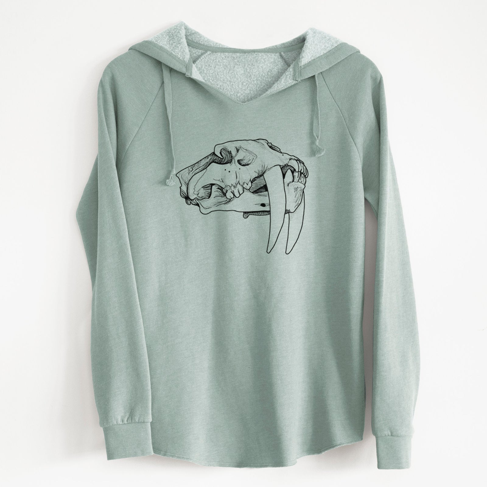 Sage green women's Cali Wave hooded sweatshirt laid flat, printed with a detailed black ink illustration of a saber-toothed tiger skull.