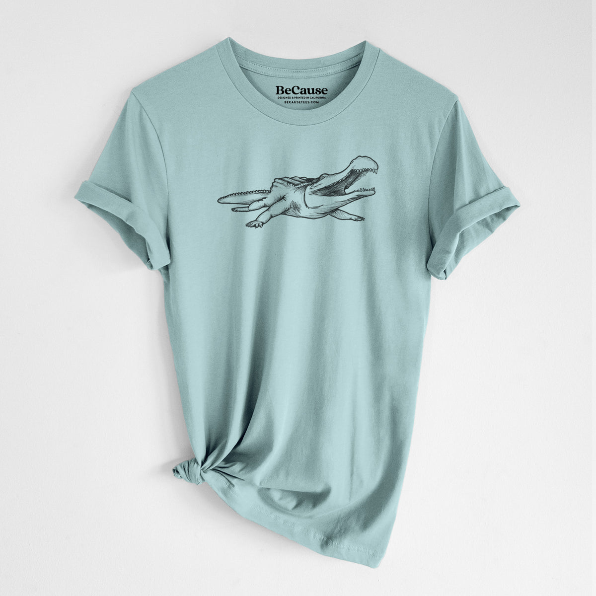 Dusty blue lightweight cotton t-shirt laid flat with the sleeves rolled, printed with a black ink illustration of a Sarcosuchus, a giant prehistoric crocodile.
