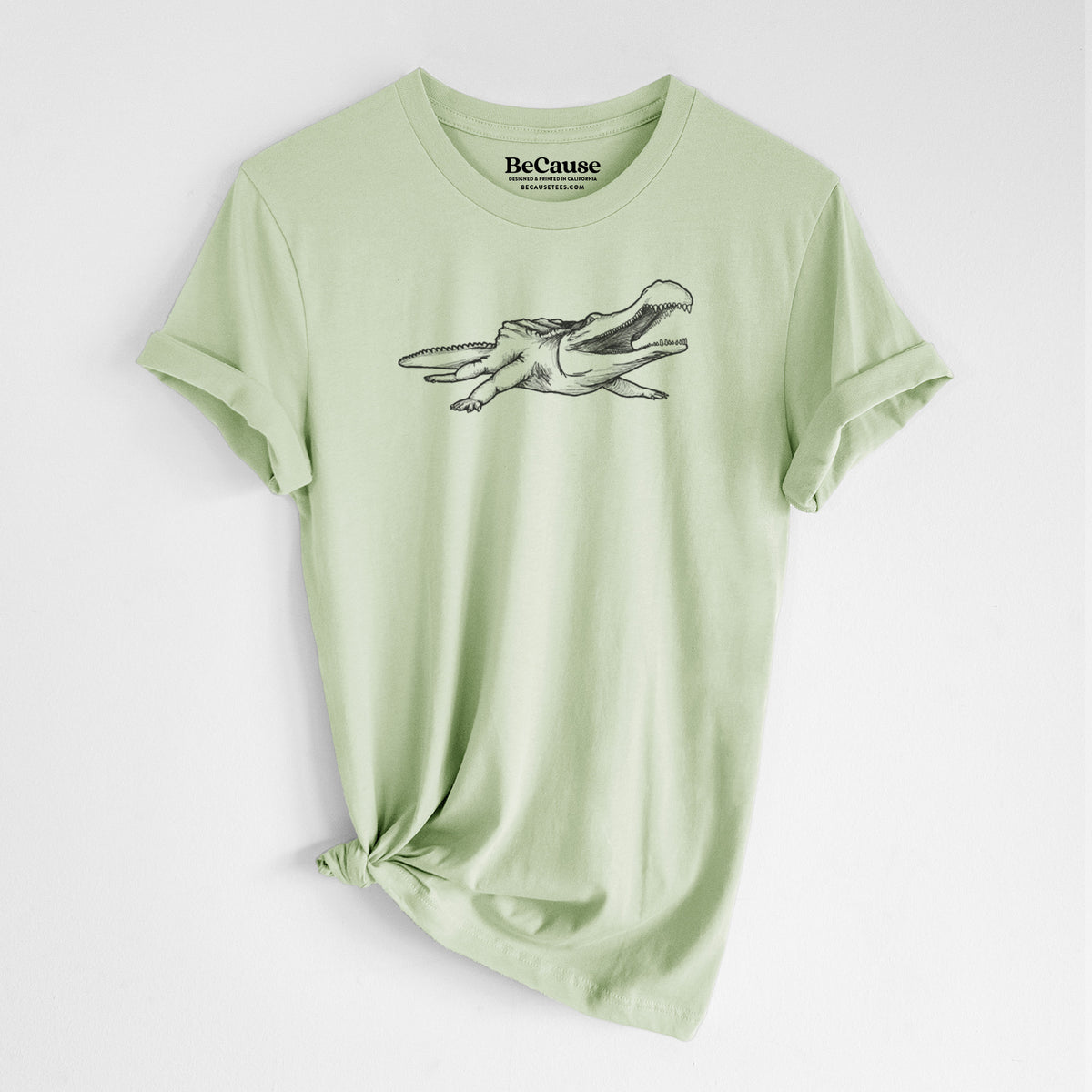 Spring green lightweight cotton t-shirt laid flat with the sleeves rolled, printed with a black ink illustration of a Sarcosuchus, a giant prehistoric crocodile.