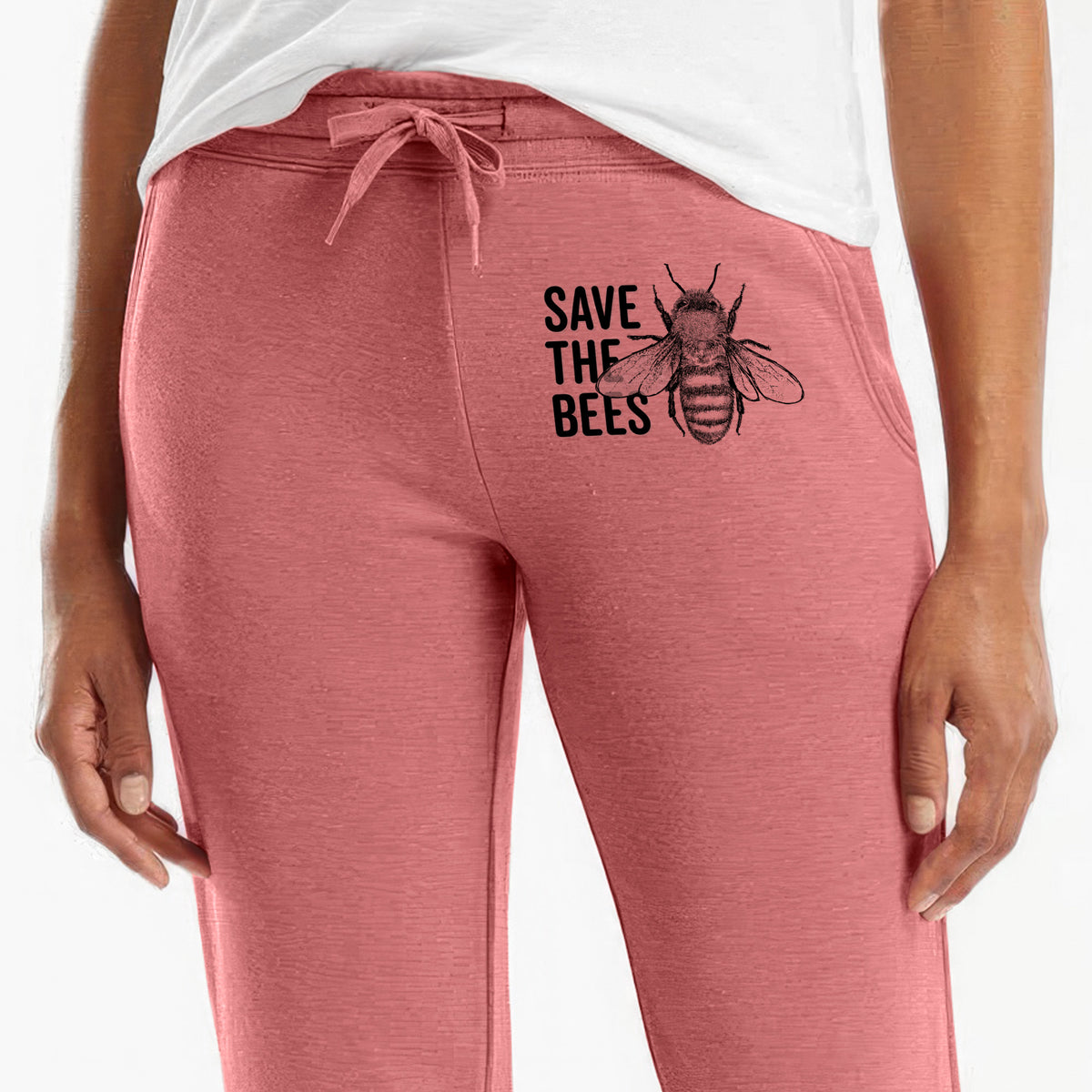 Front of dusty rose Cali Wave sweatpants, printed with bold black words reading Save the Bees beside a detailed honey bee illustration on the leg.