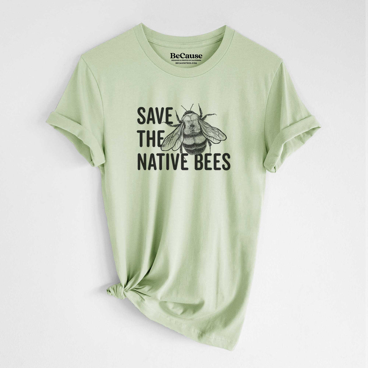 Spring green lightweight cotton t-shirt laid flat with the sleeves rolled, printed with bold black words reading Save the Native Bees beside a detailed bee illustration.