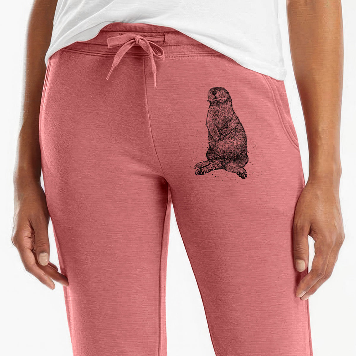Front of dusty rose Cali Wave sweatpants, printed with a detailed black ink illustration of a sea otter sitting upright on the leg.