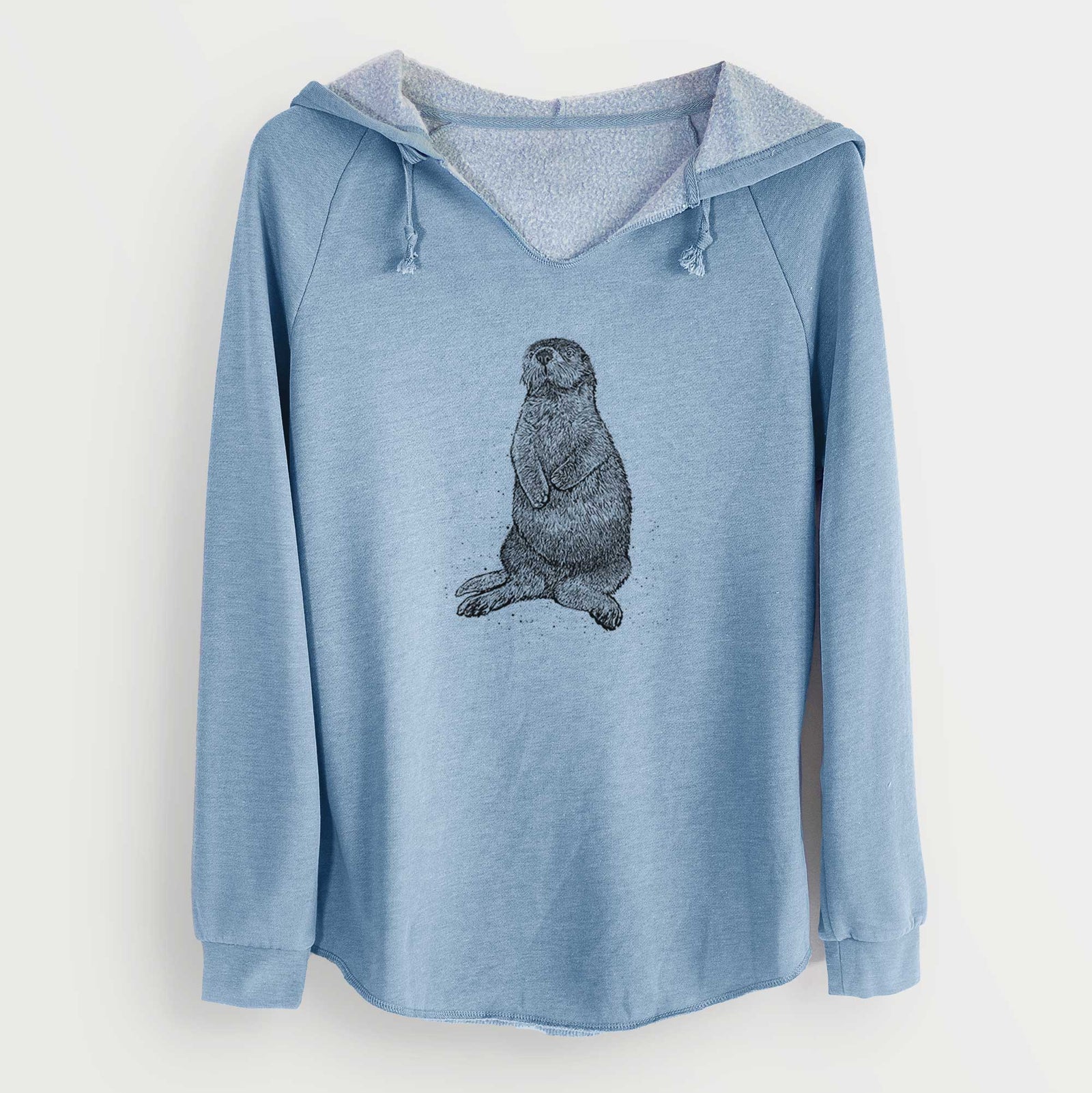 Misty blue women's Cali Wave hooded sweatshirt laid flat, printed with a detailed black ink illustration of a sea otter sitting upright.